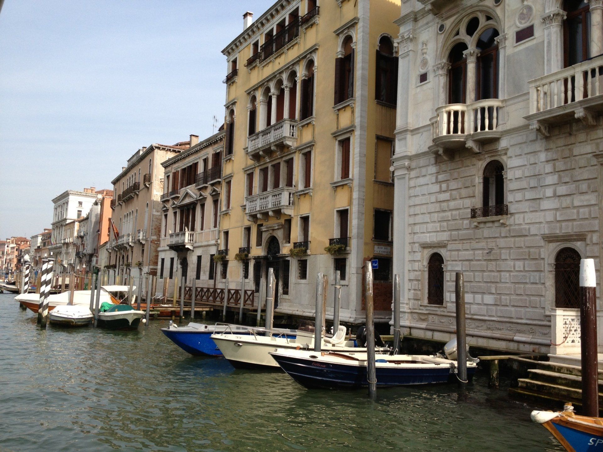 Eine Reihe von Booten liegt vor einem Gebäude vor Anker