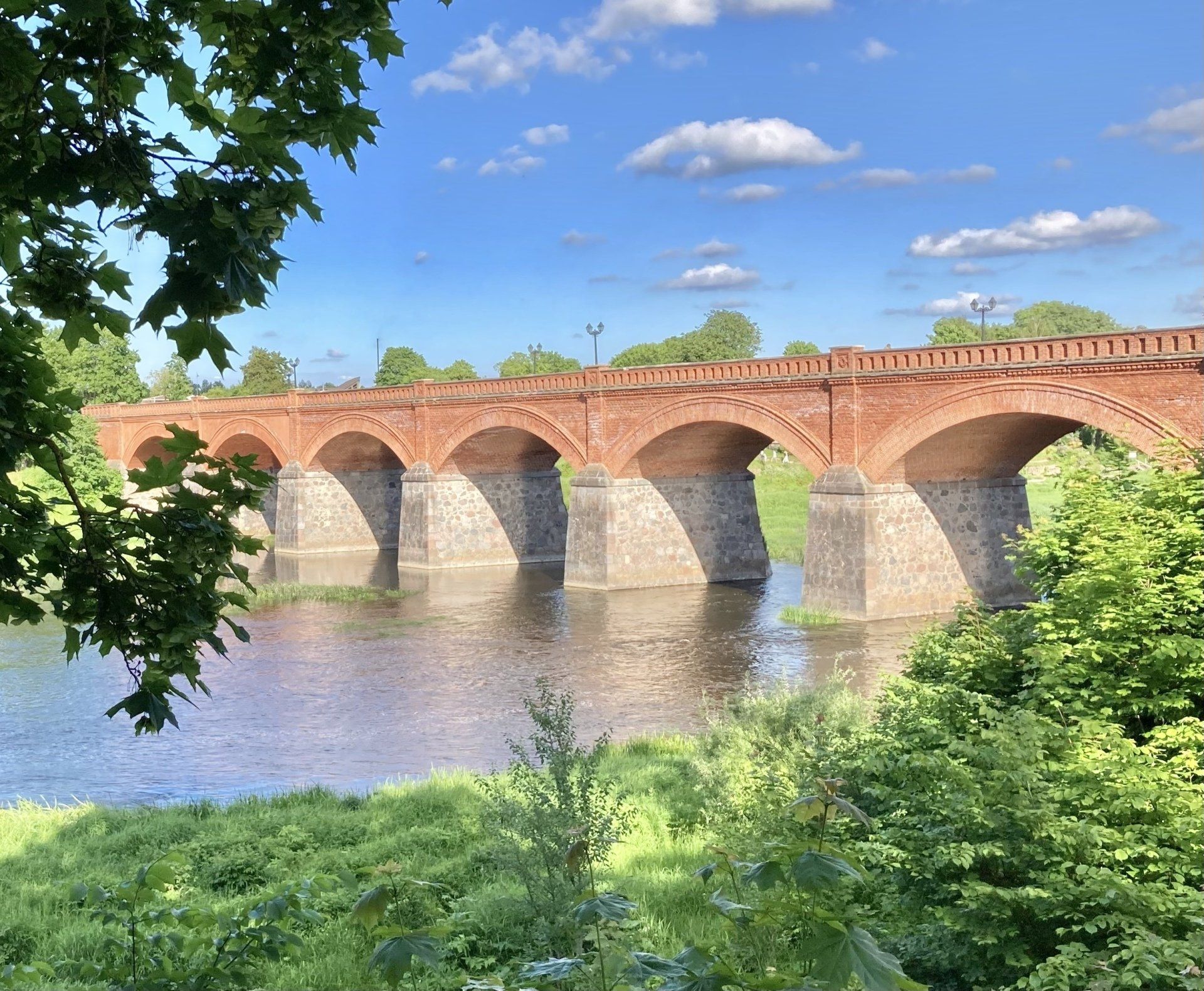 Eine Brücke über einen Fluss mit Bäumen im Vordergrund