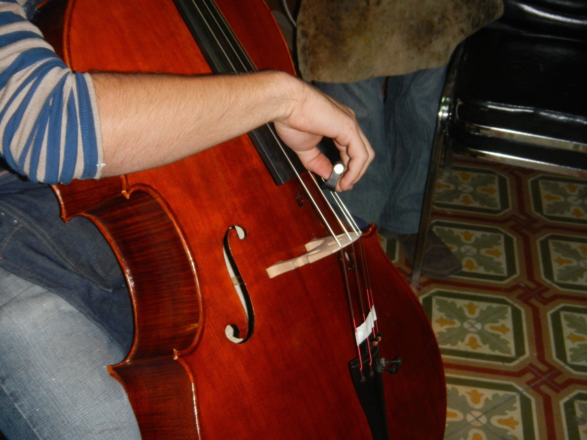 Ein Mann spielt Kontrabass auf einem gefliesten Boden