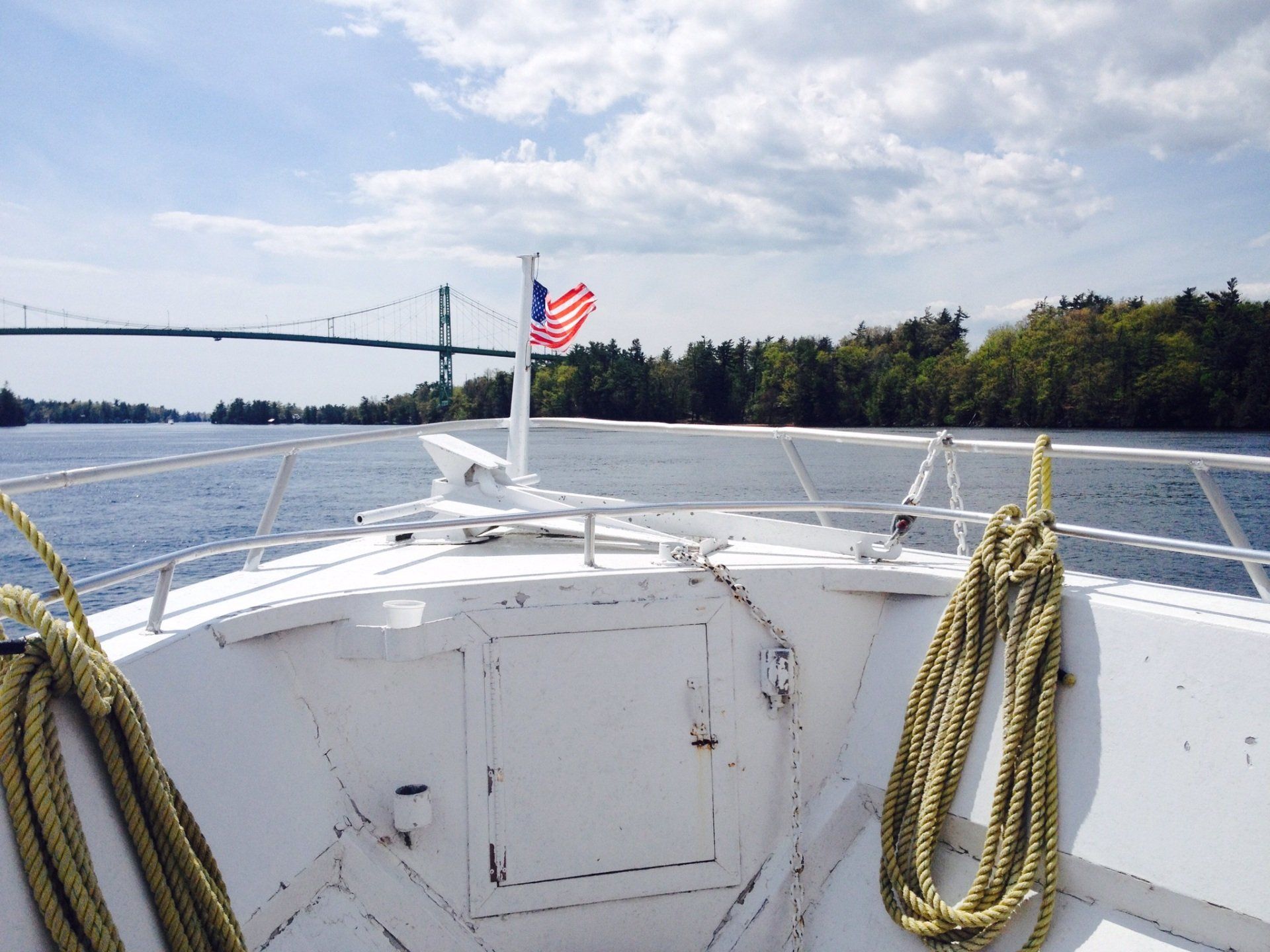 Ein Boot schwimmt auf einem Gewässer mit einer Brücke im Hintergrund
