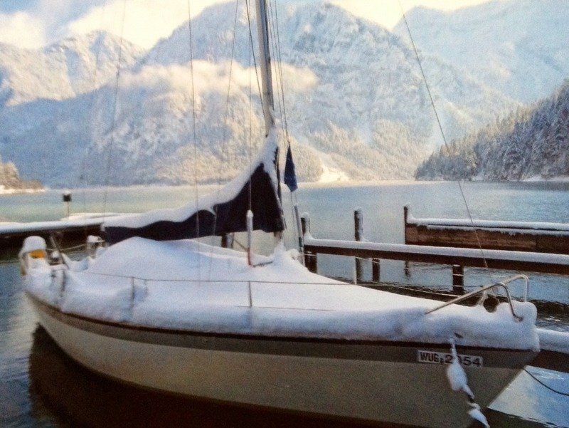 Ein mit Schnee bedecktes Boot liegt an einem Dock