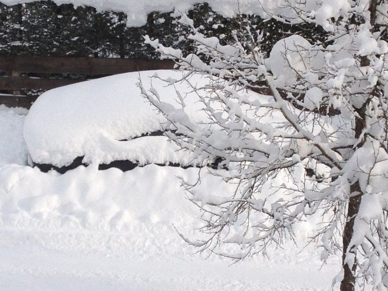 Ein Auto ist mit einer dicken Schneeschicht bedeckt