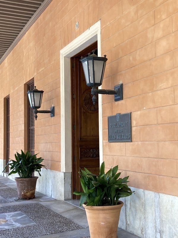 Ein Backsteingebäude mit zwei Topfpflanzen davor