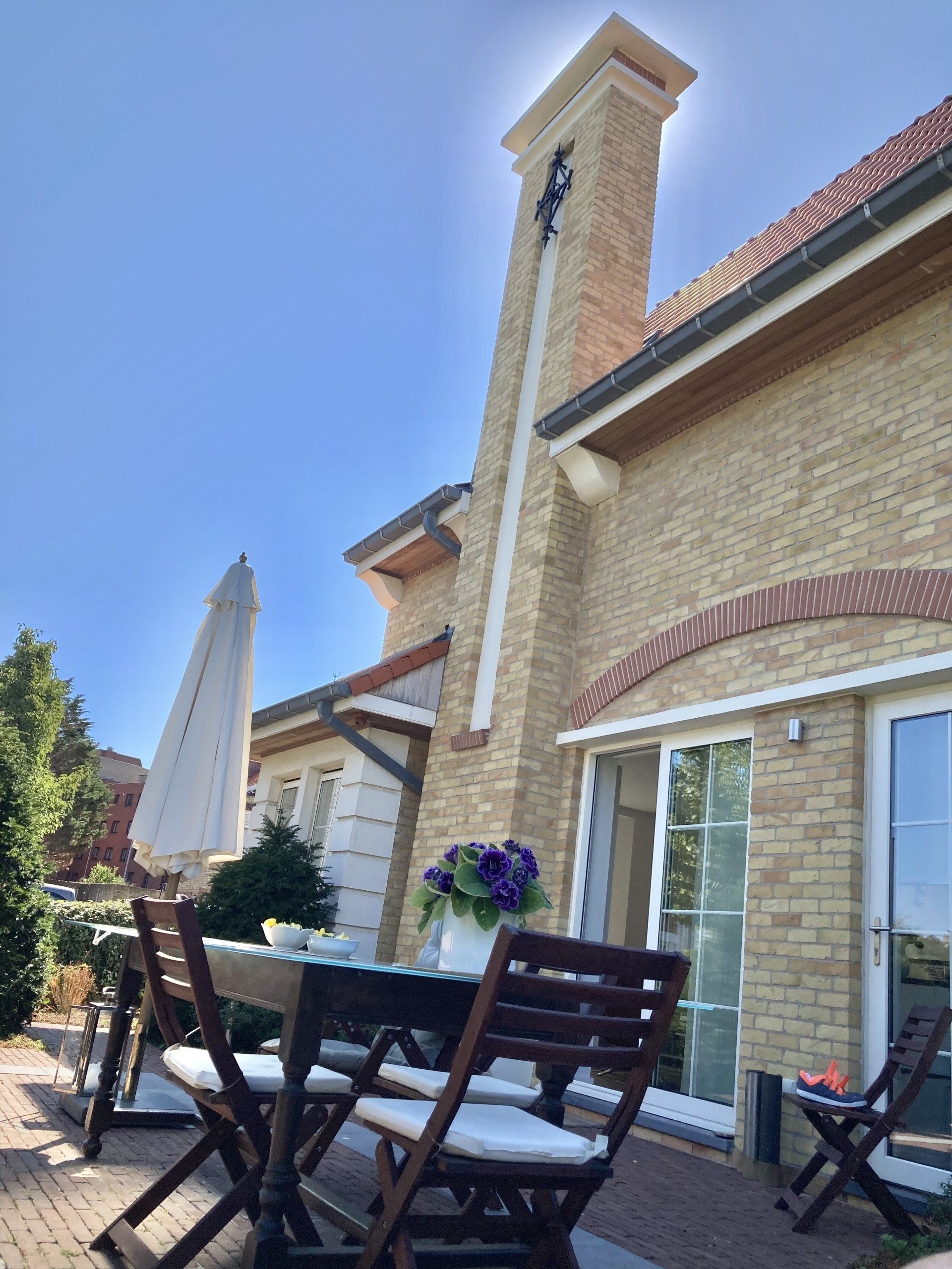 Ein Backsteinhaus mit einem Tisch und Stühlen davor