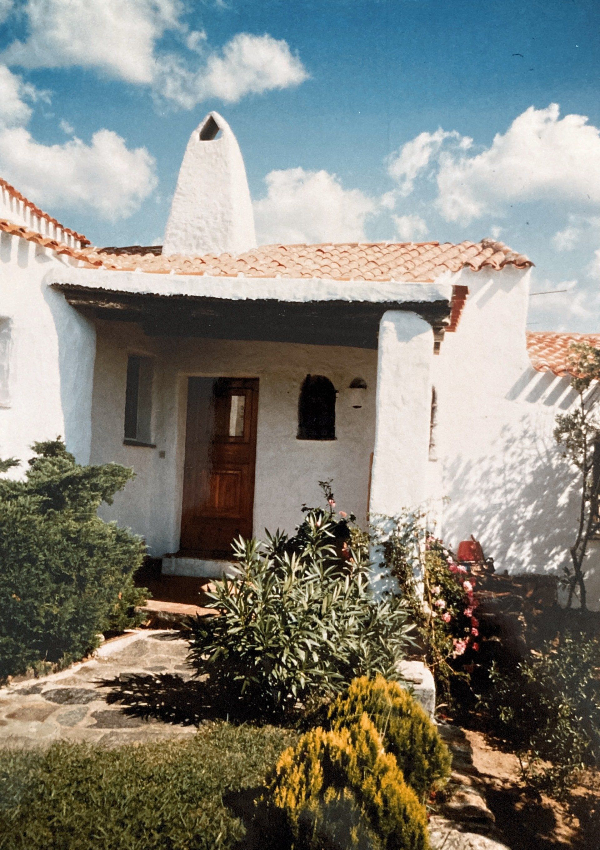 Ein weißes Haus mit einem Schornstein auf dem Dach