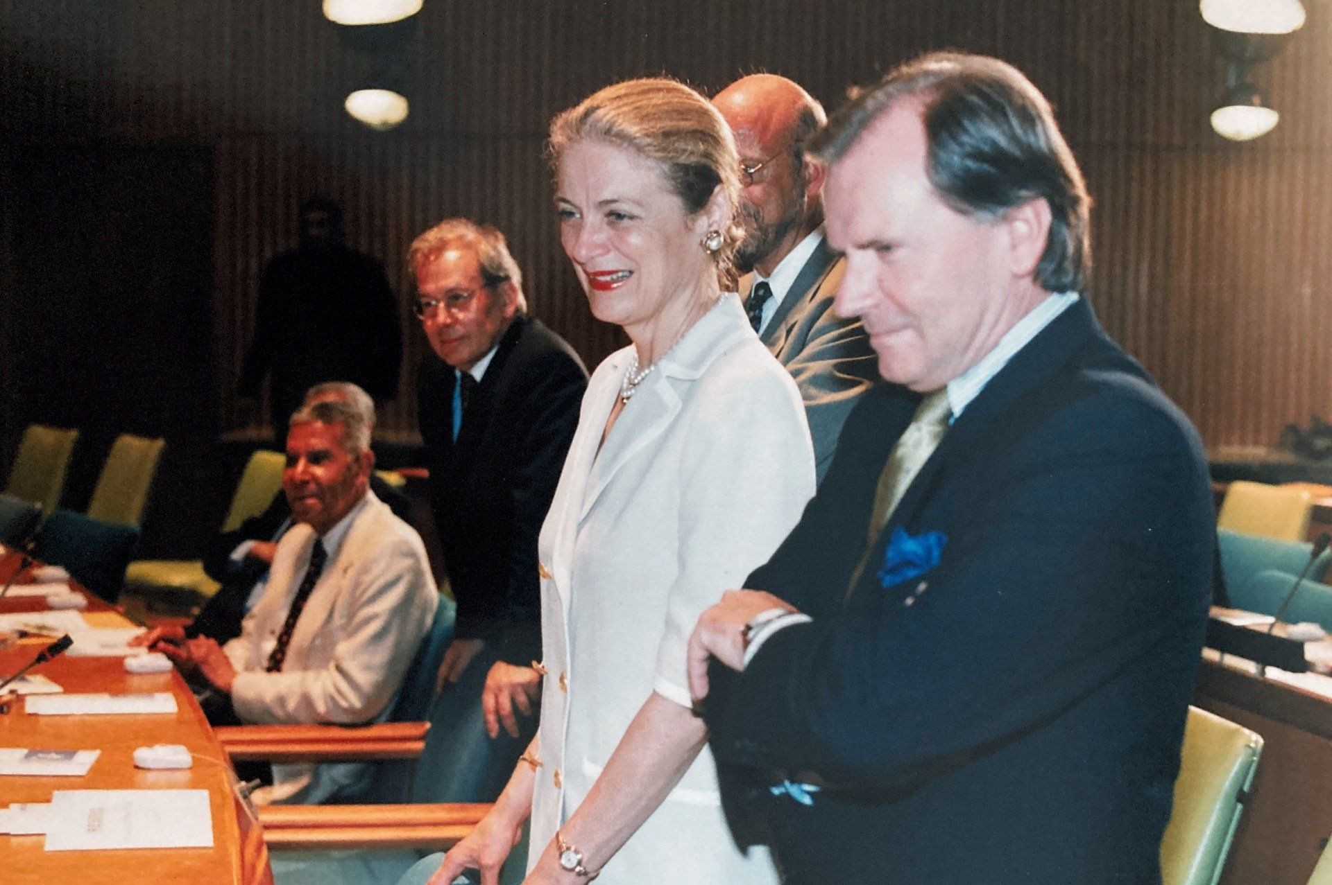 Eine Frau im weißen Anzug steht neben einem Mann im schwarzen Anzug