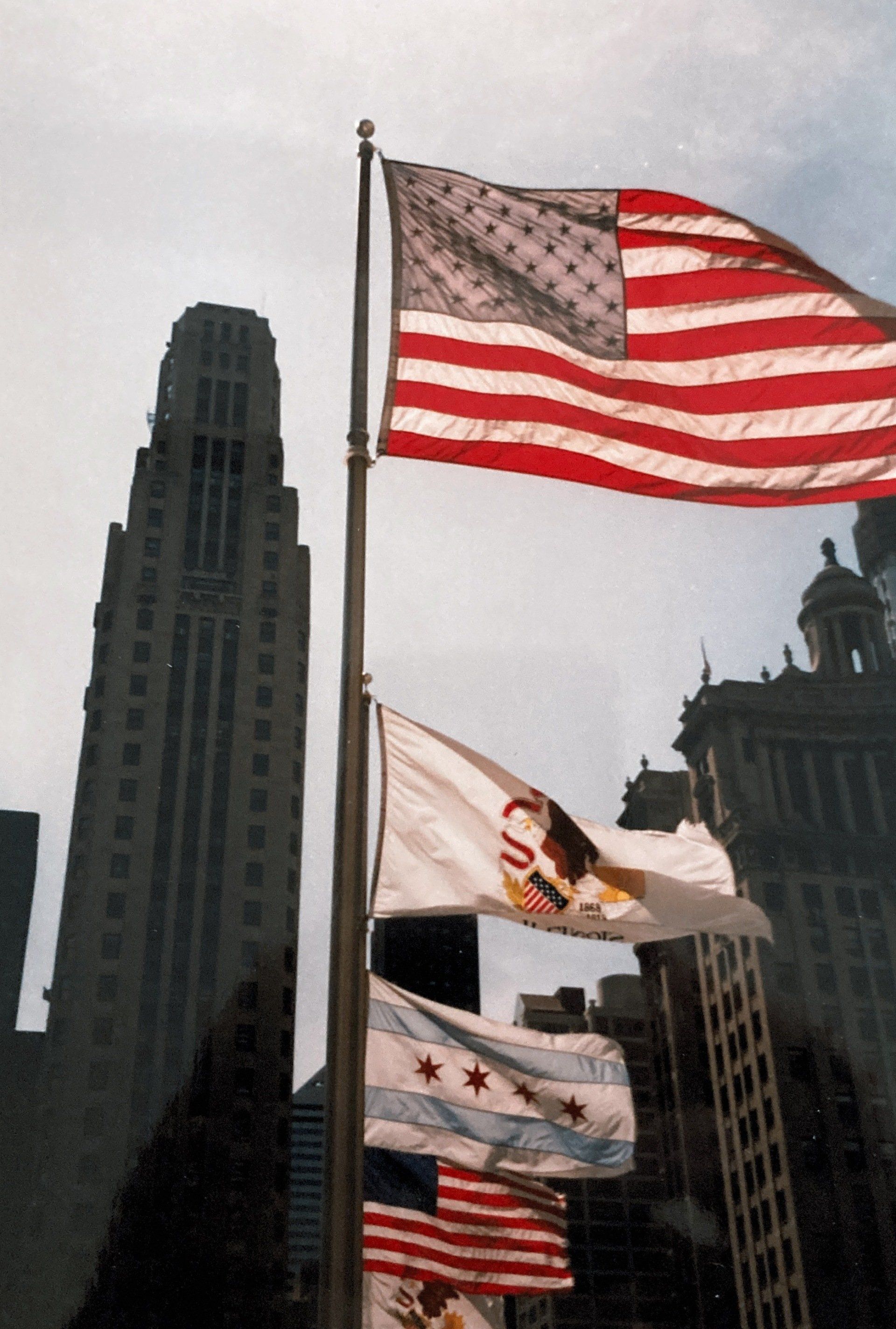 Mehrere Flaggen wehen vor der Skyline einer Stadt