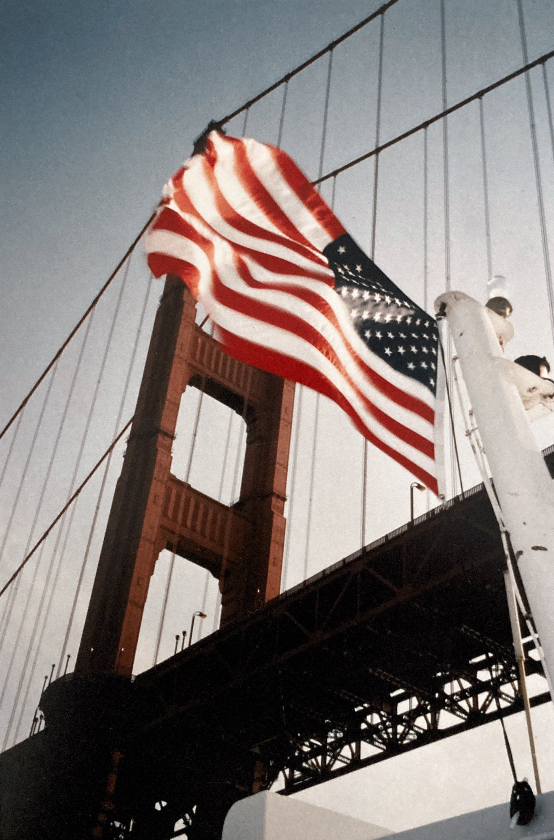 Vor der Golden Gate Bridge weht eine amerikanische Flagge
