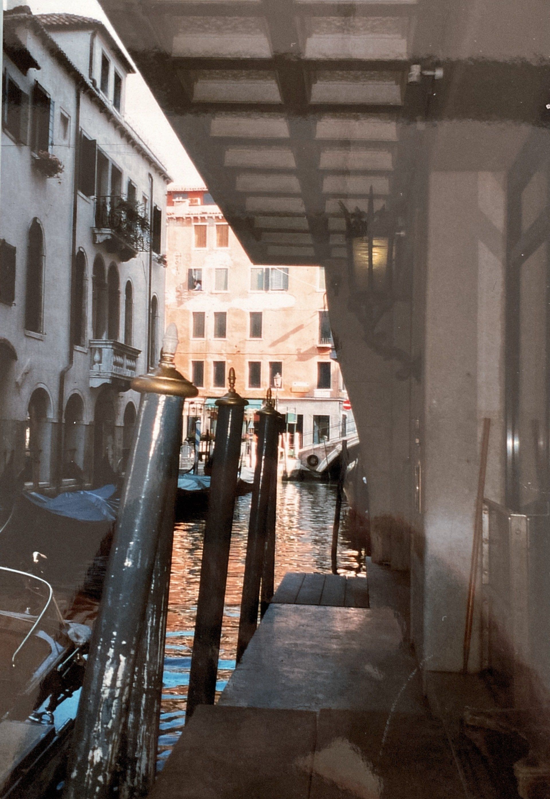 Eine Spiegelung eines Gebäudes in einem Fenster mit einem Kanal im Hintergrund