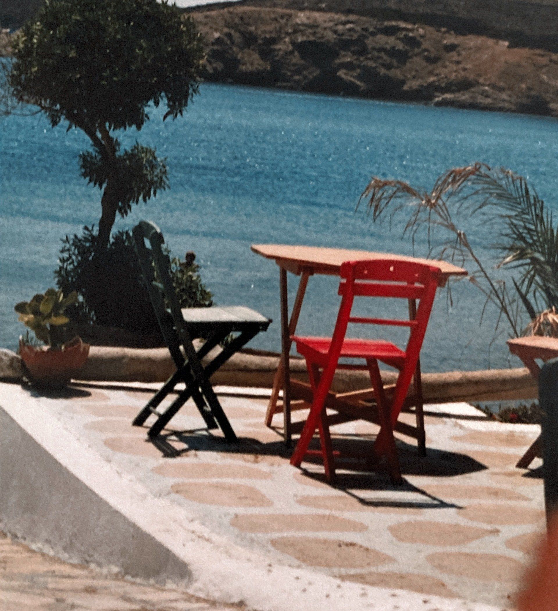 Ein Tisch und Stühle auf einer Terrasse mit Blick auf ein Gewässer
