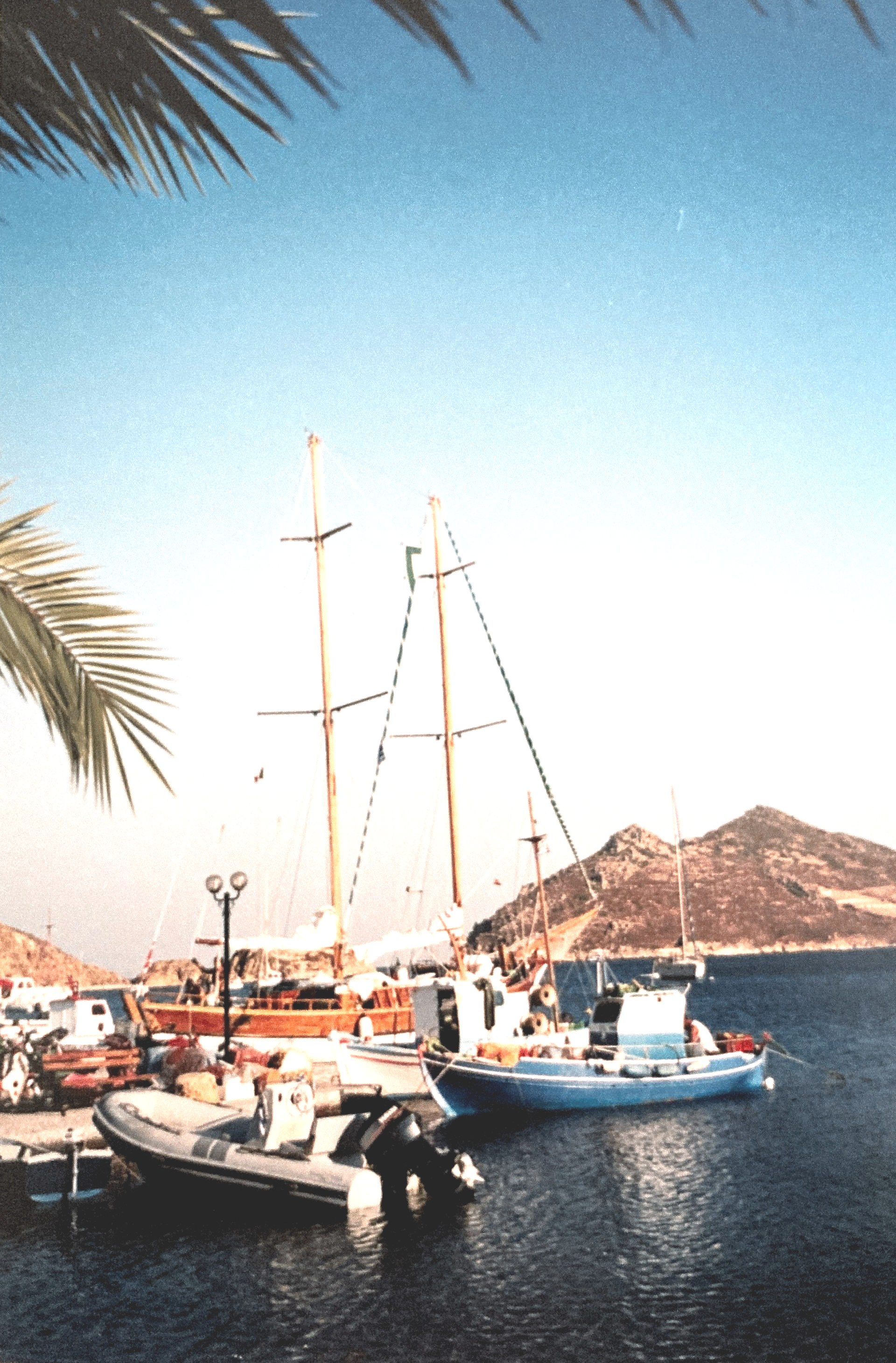 Boote liegen in einem Hafen mit Bergen im Hintergrund