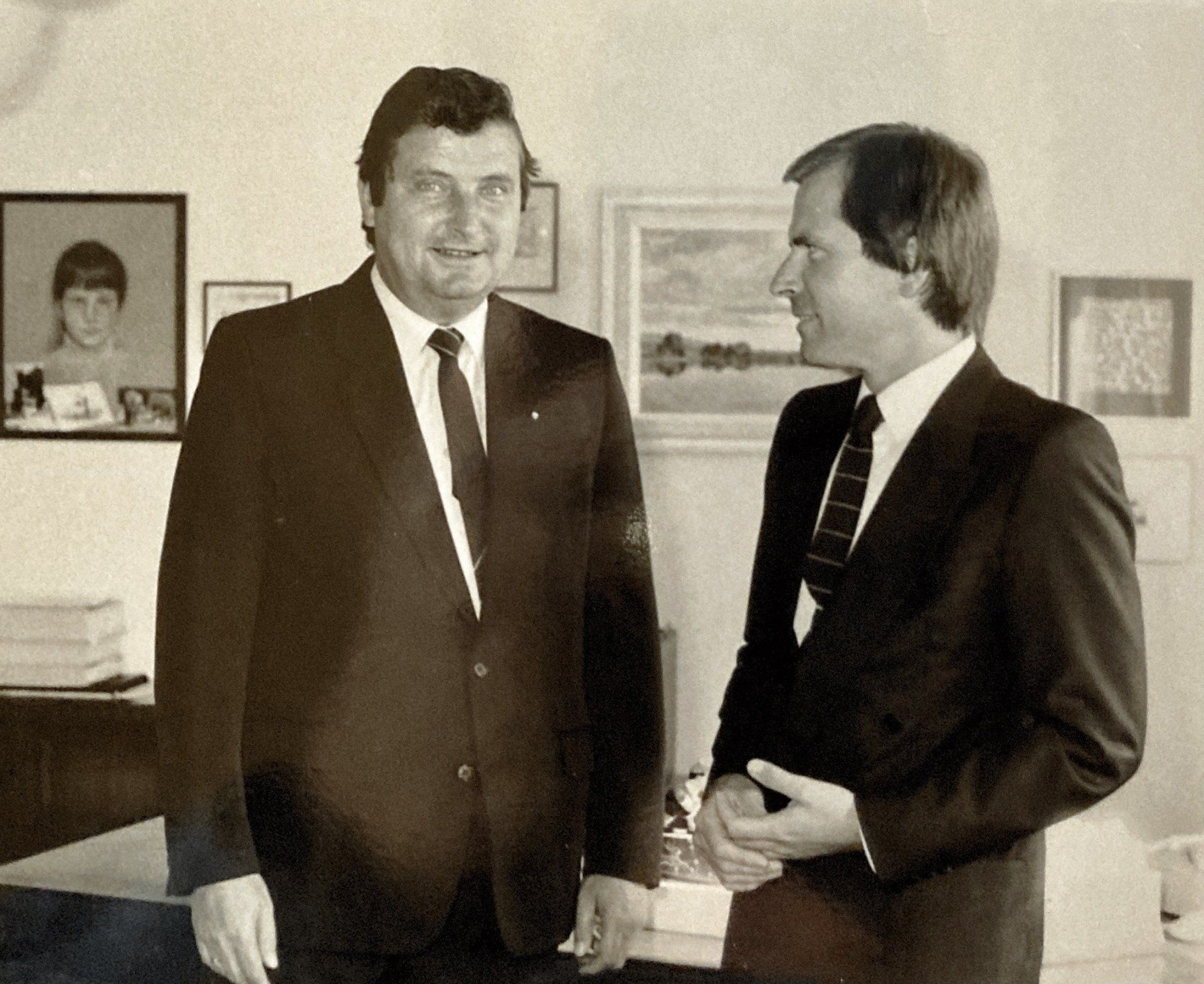 Zwei Männer in Anzug und Krawatte stehen nebeneinander