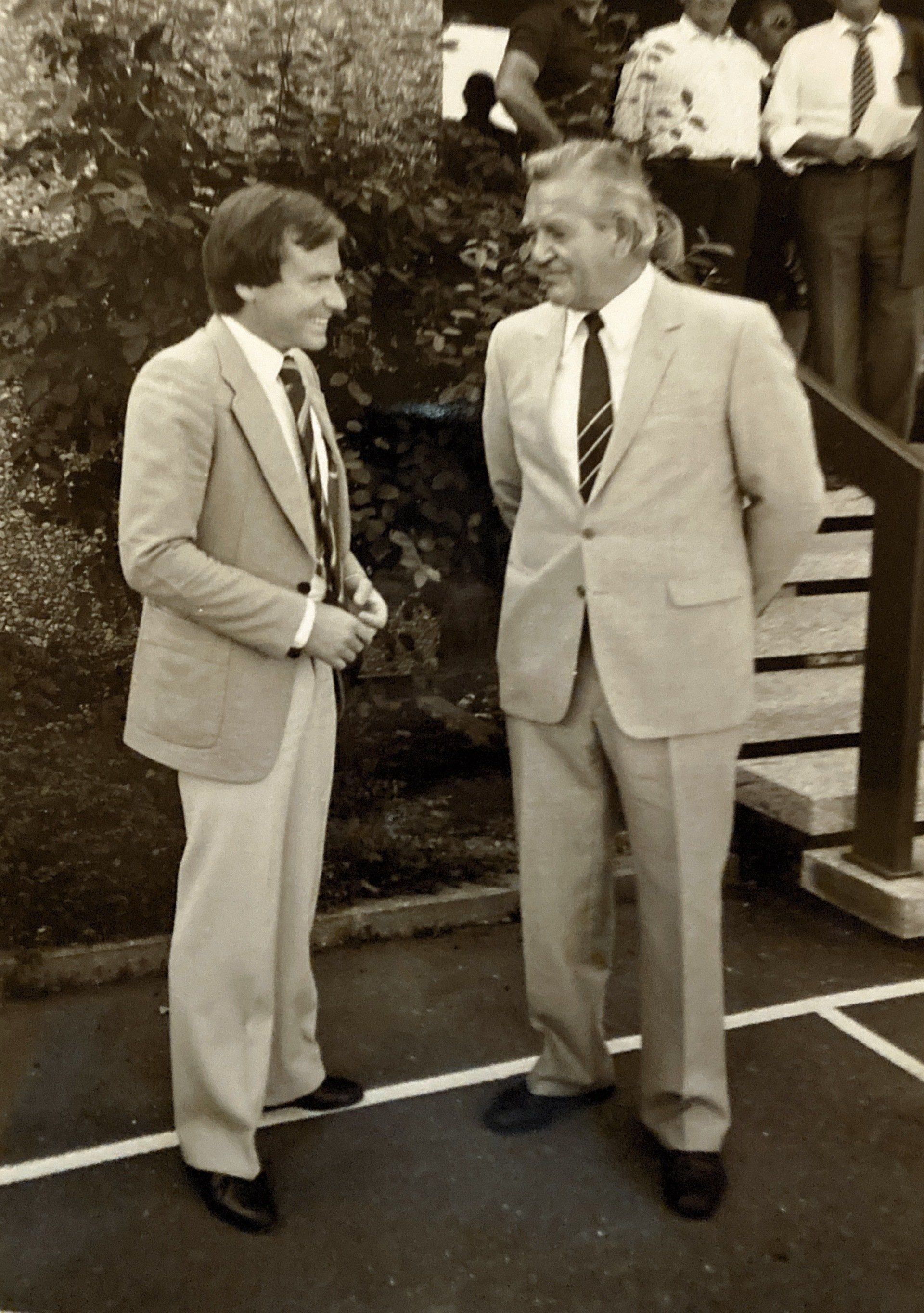 Zwei Männer in Anzug und Krawatte stehen nebeneinander