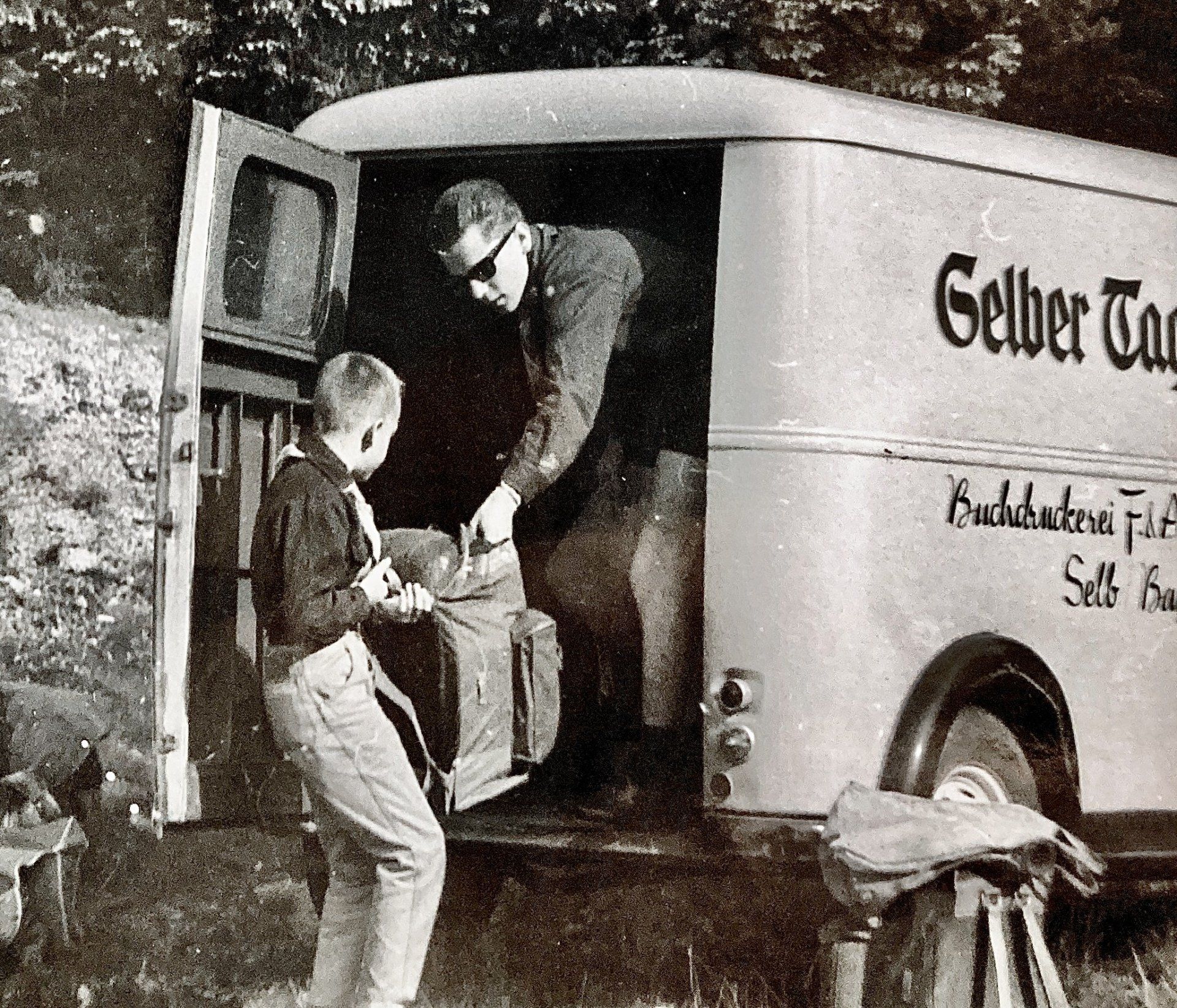 Ein Mann und ein Junge steigen aus einem Lieferwagen mit der Aufschrift „Gelber Tag“