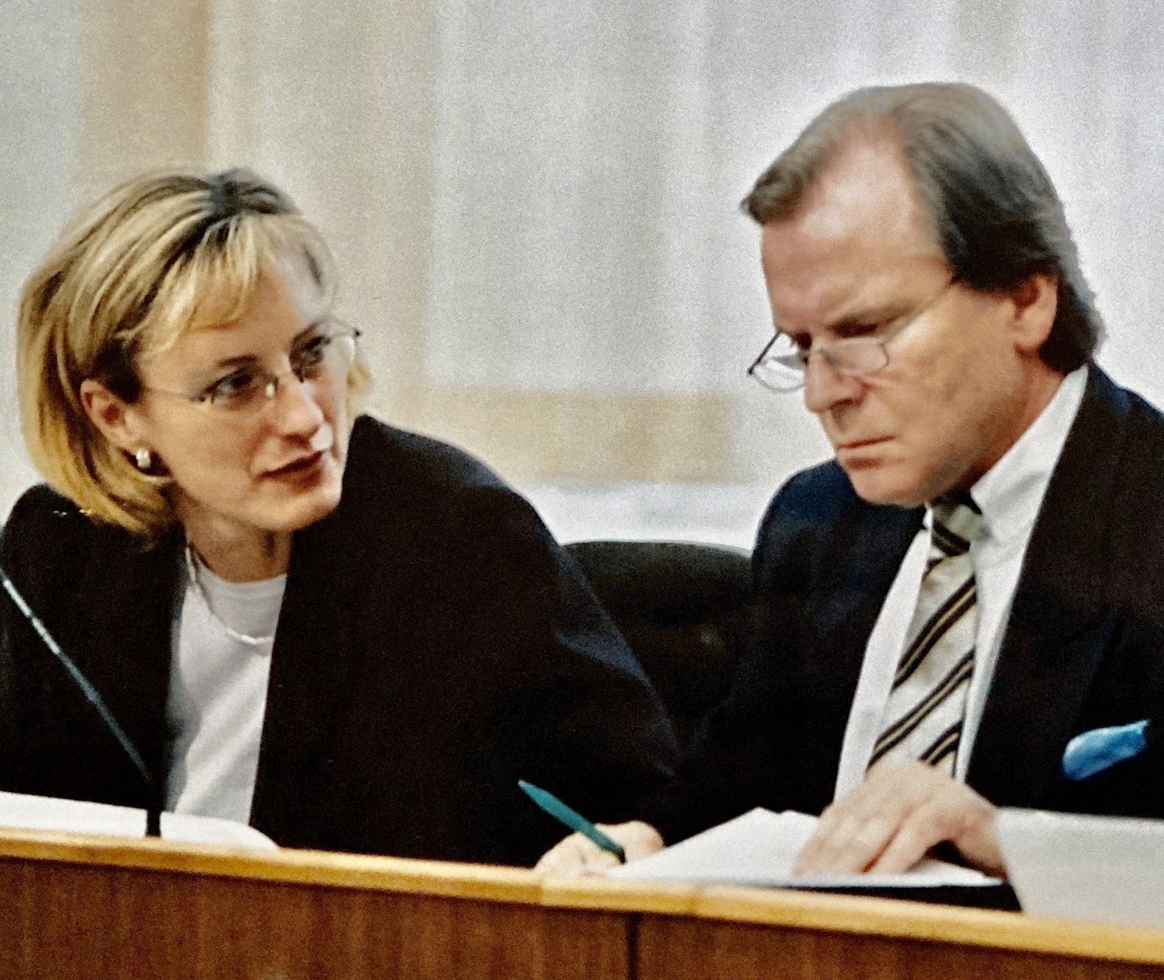 Ein Mann und eine Frau sitzen an einem Schreibtisch und unterhalten sich