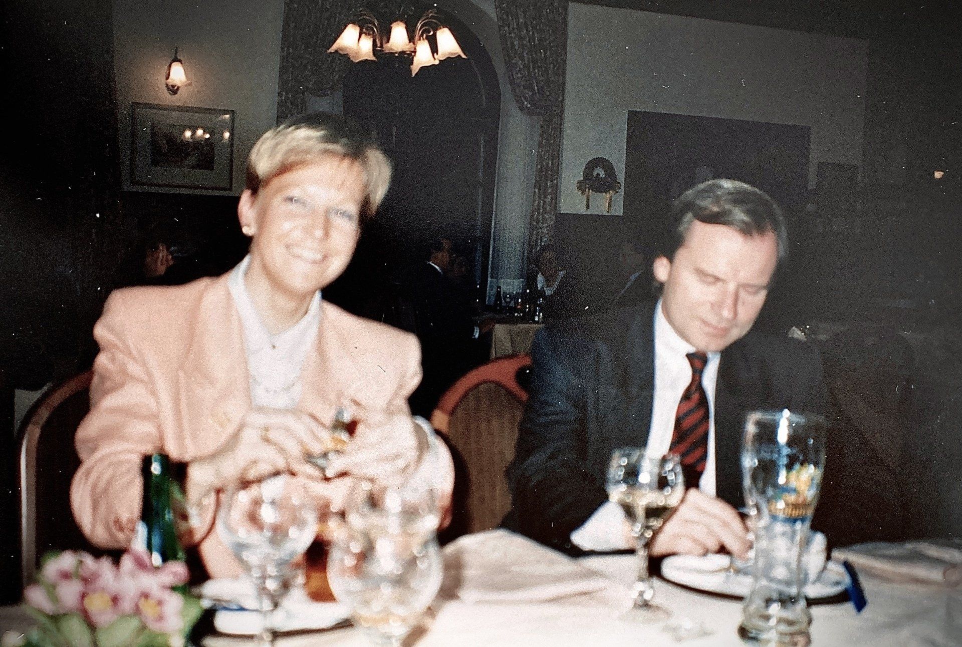 Ein Mann und eine Frau sitzen mit Weingläsern an einem Tisch.