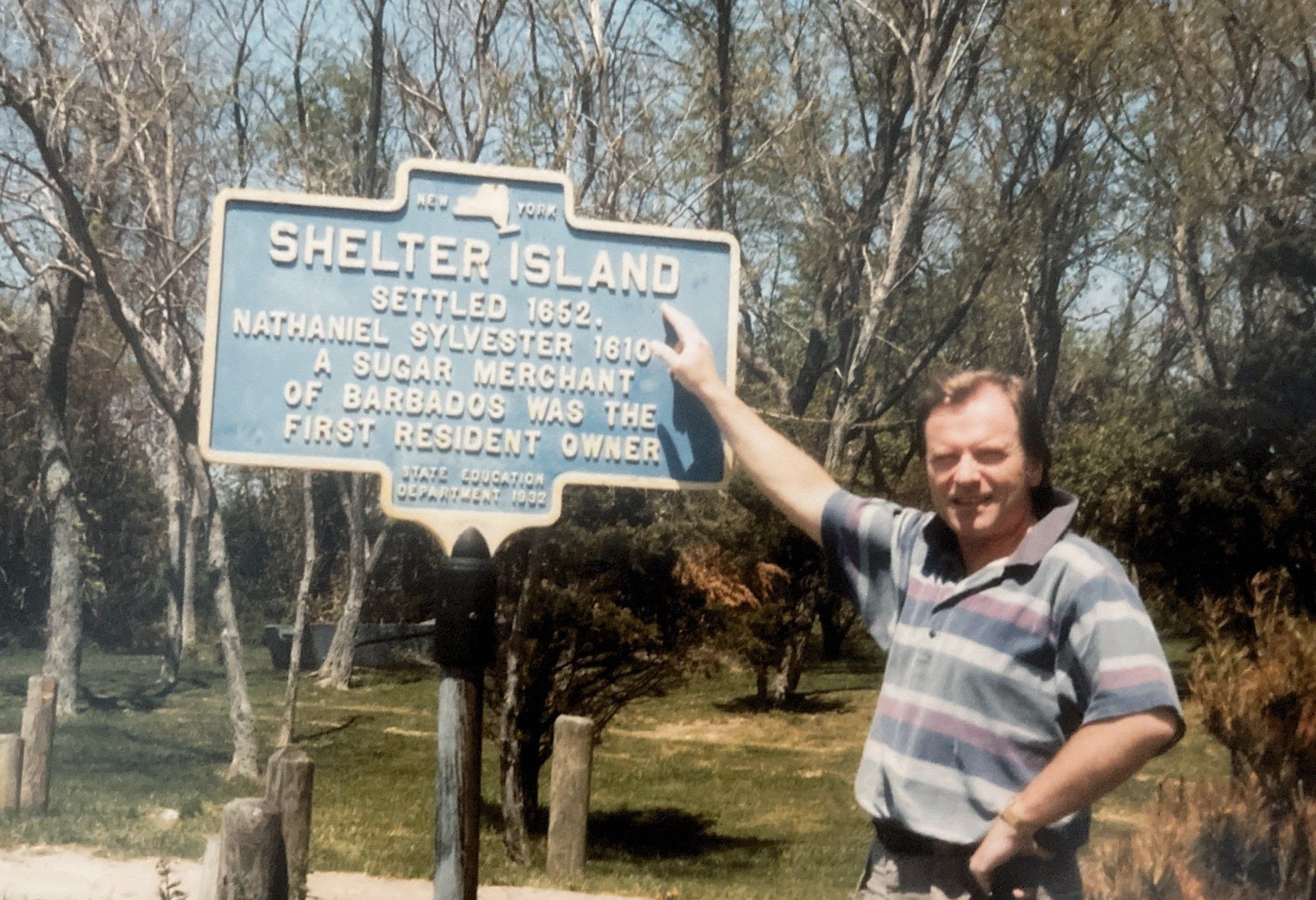 Ein Mann steht vor einem Schild mit der Aufschrift „Shelter Island“