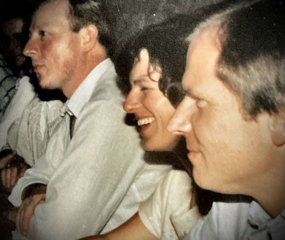 Eine Gruppe von Menschen sitzt in einer Reihe und einer von ihnen lächelt