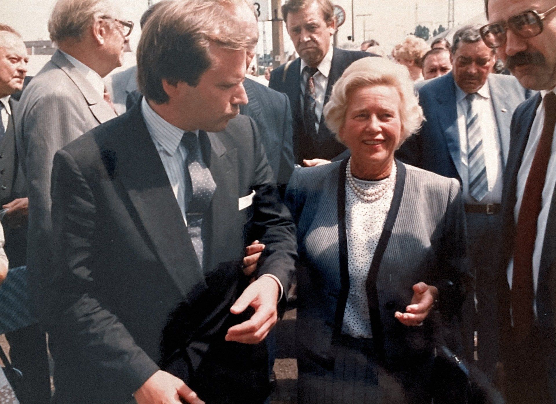 Ein Mann in Anzug und Krawatte spricht mit einer Frau