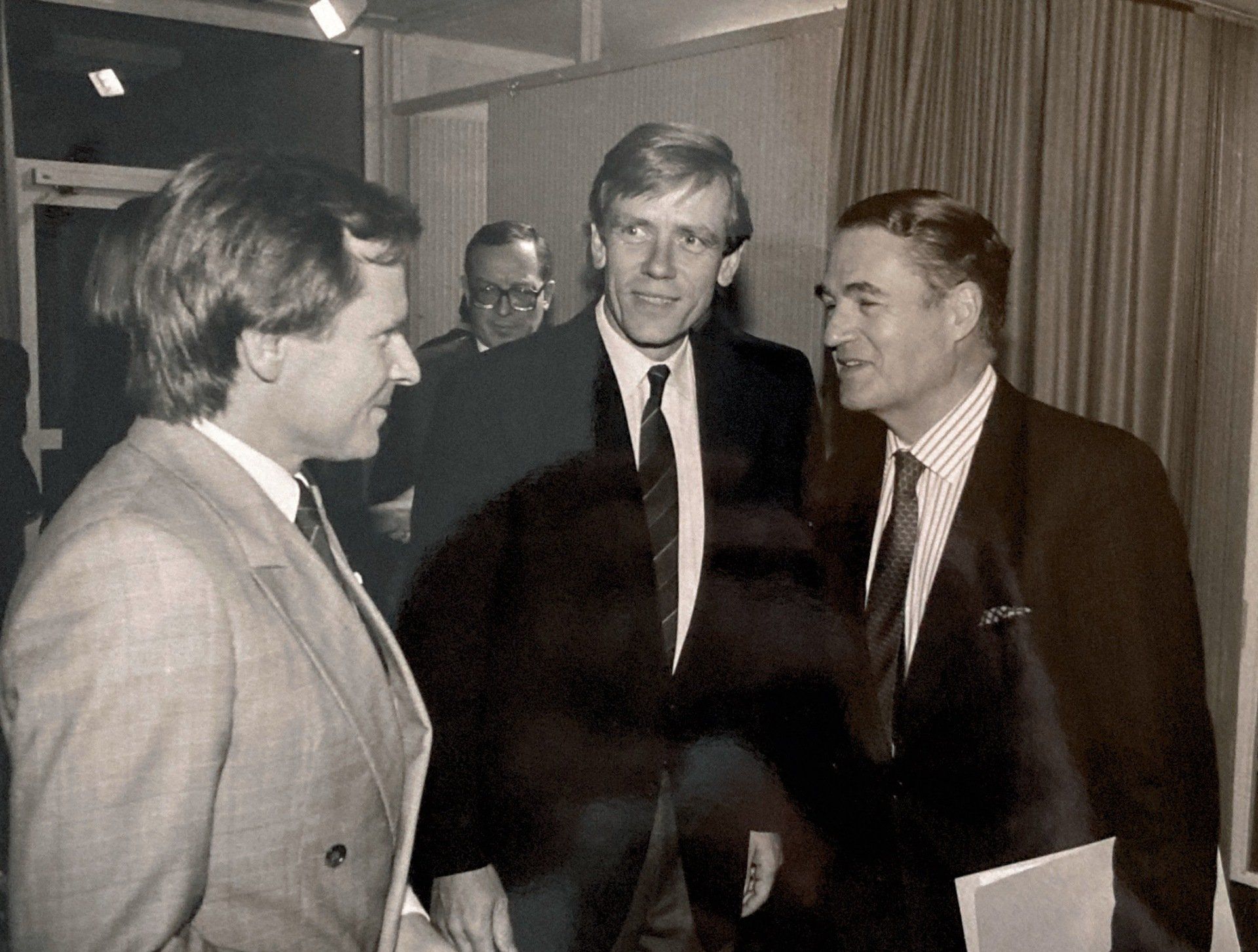 Ein Schwarzweißfoto von drei Männern in Anzug und Krawatte