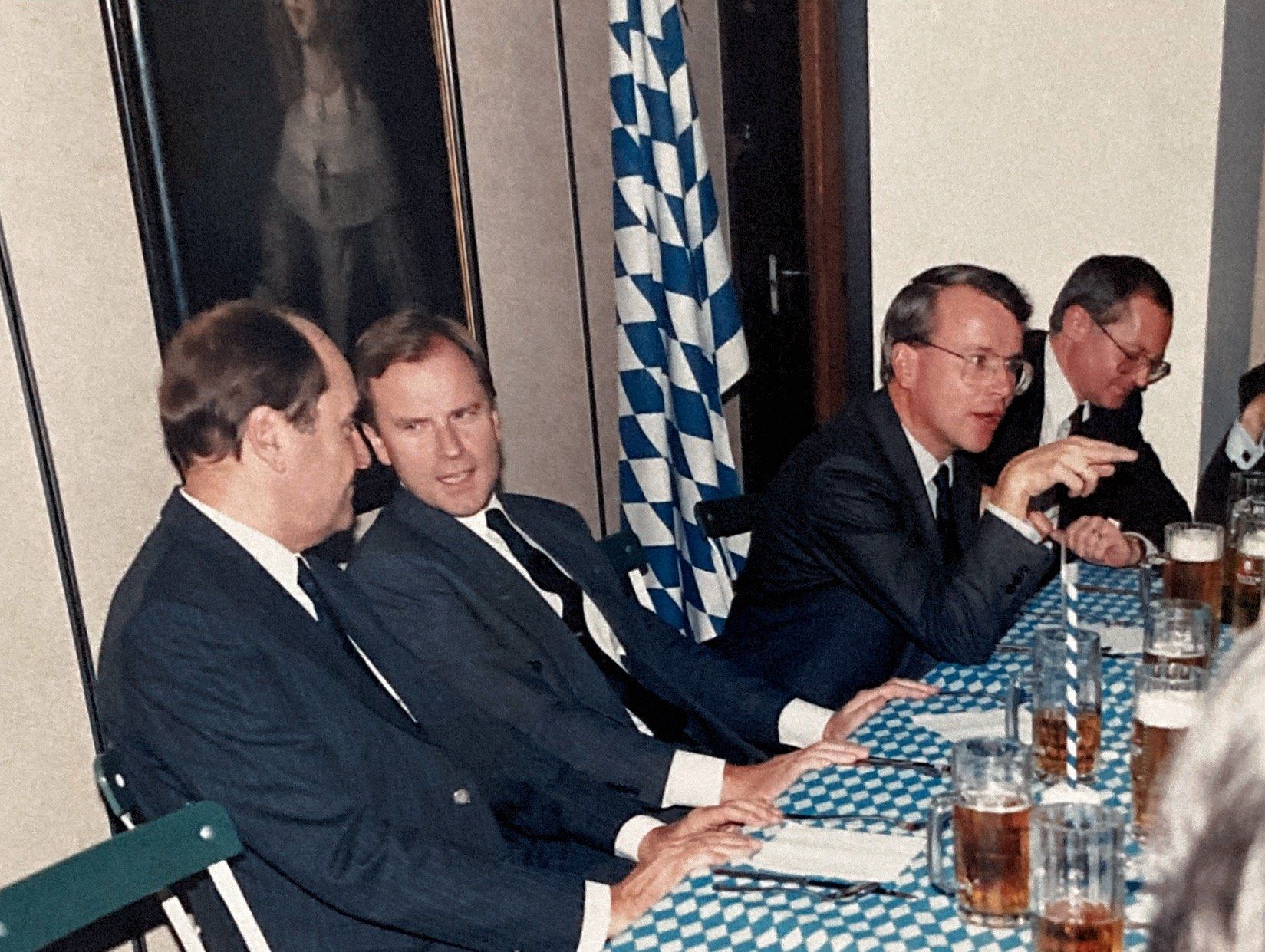 Eine Gruppe von Männern sitzt mit Bierkrügen an einem Tisch