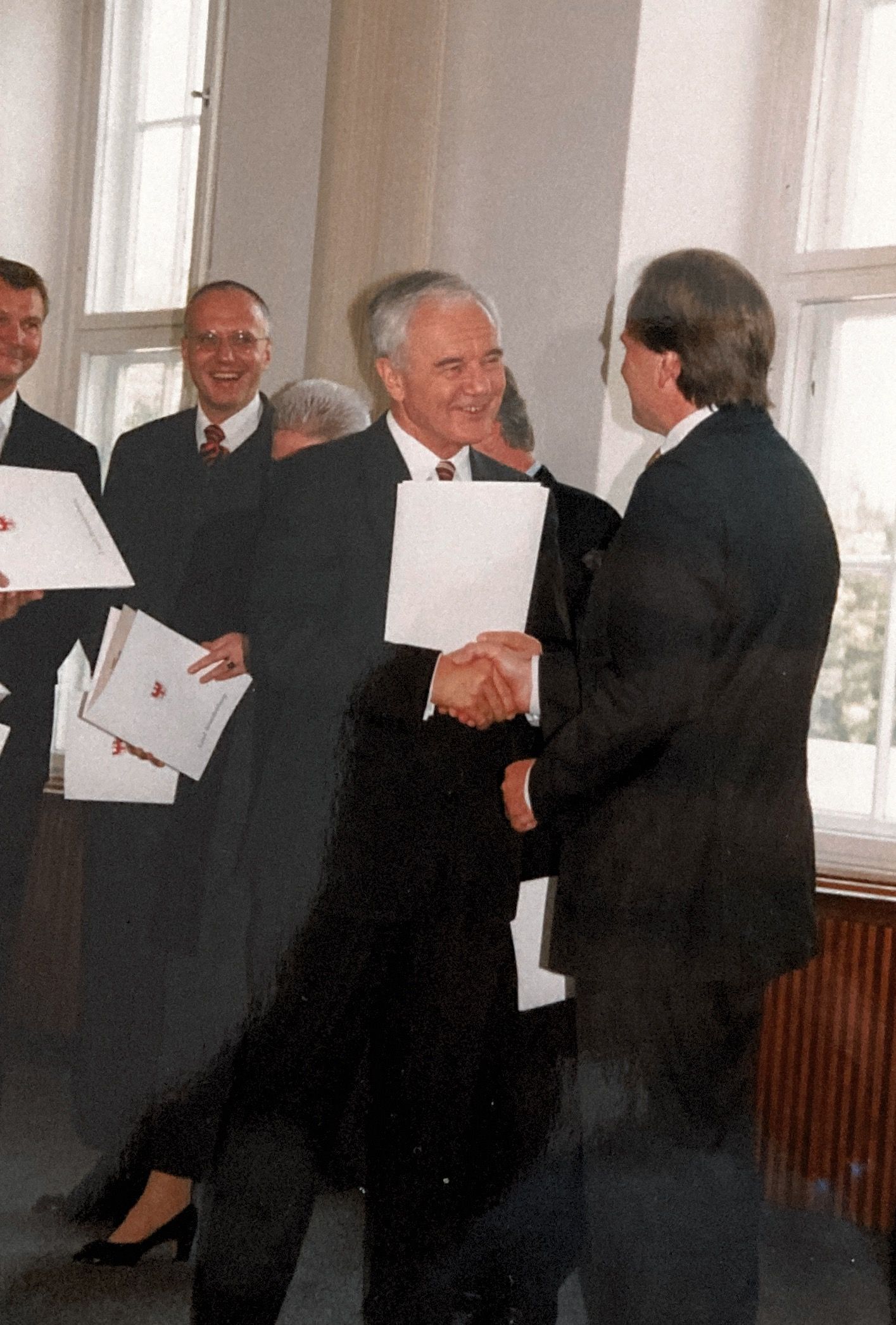 Ein Mann im Anzug schüttelt einem anderen Mann die Hand