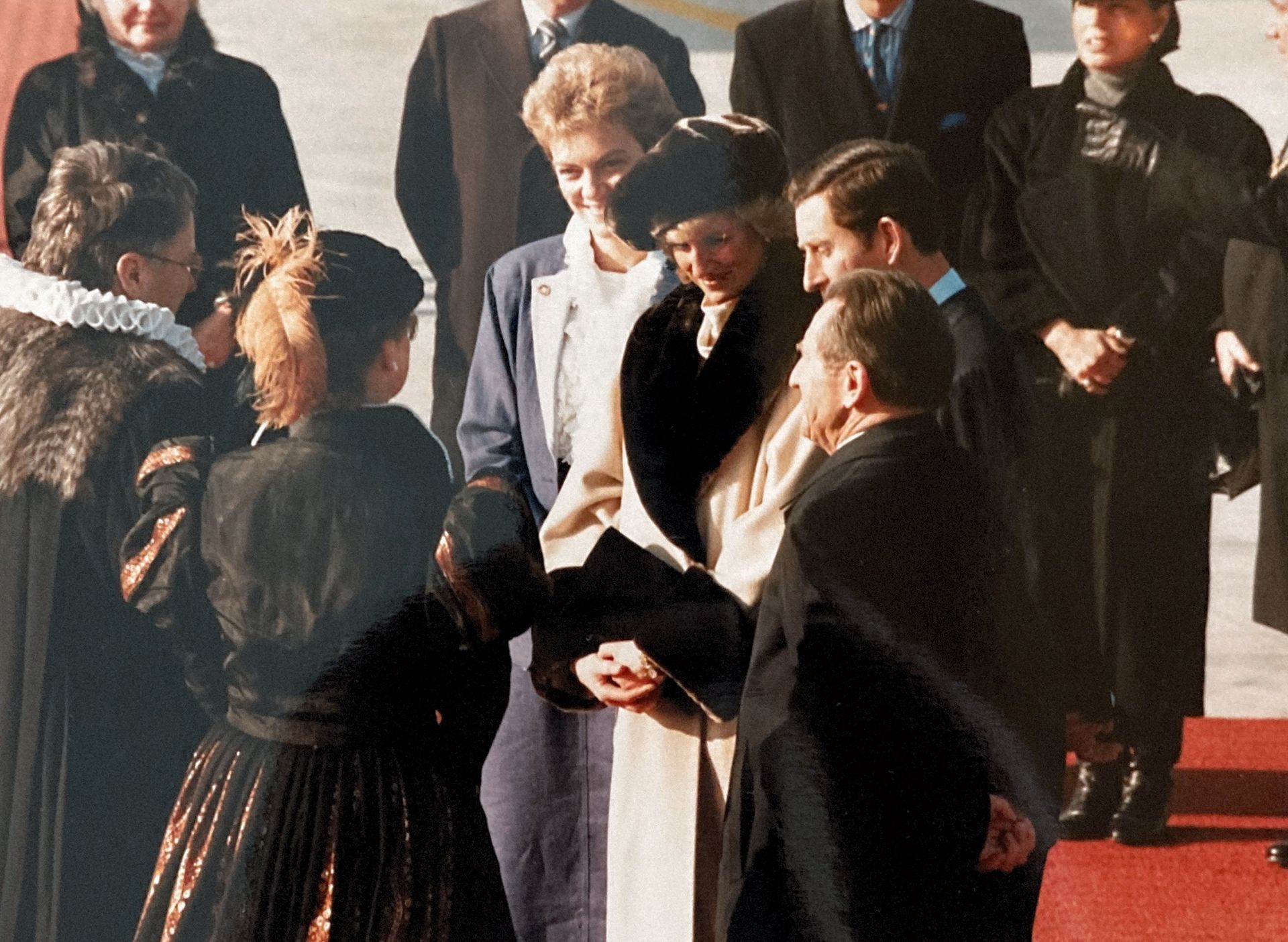 Eine Gruppe von Menschen schüttelt sich auf einem roten Teppich die Hände