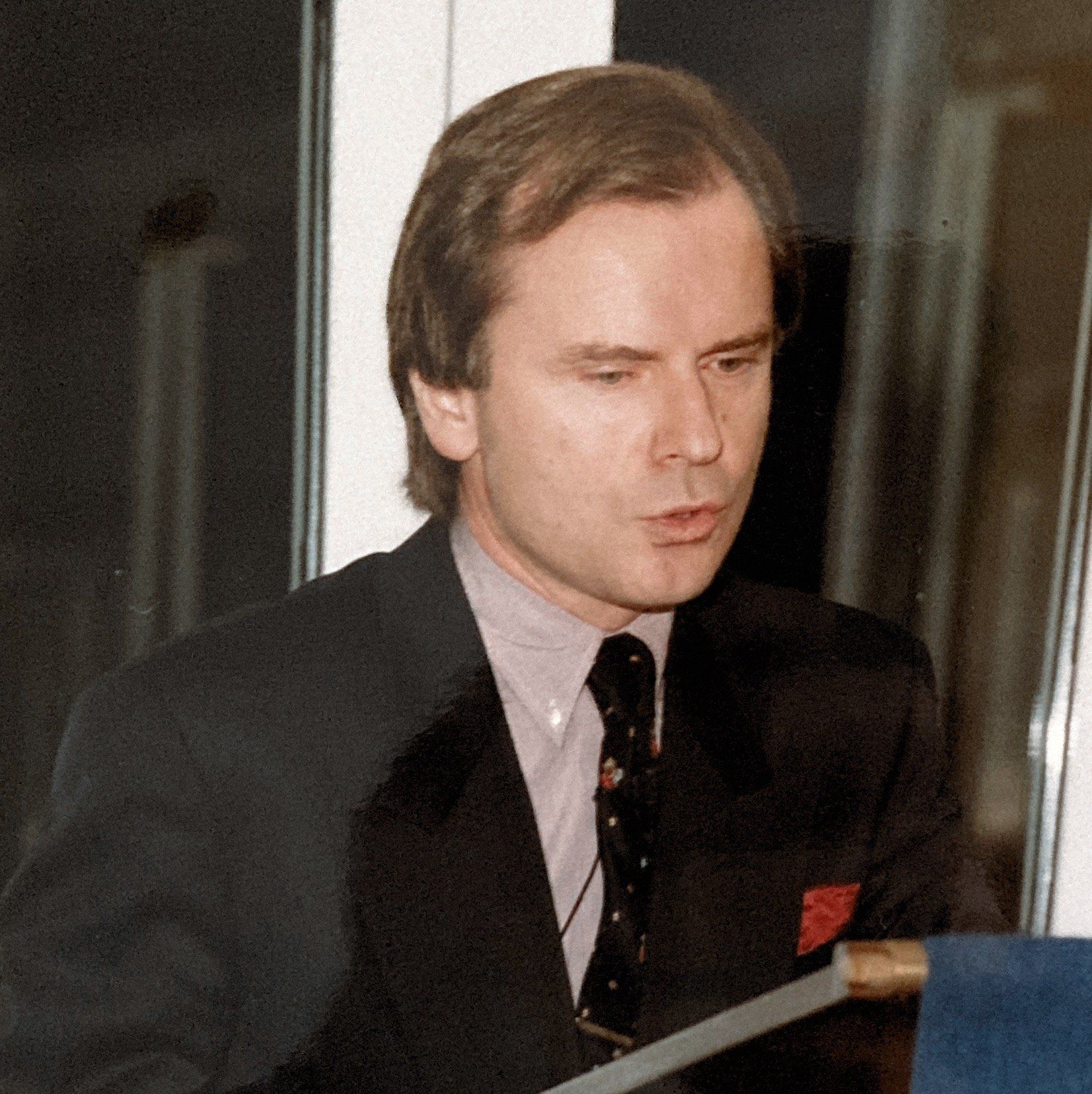 Ein Mann in Anzug und Krawatte hält eine Rede