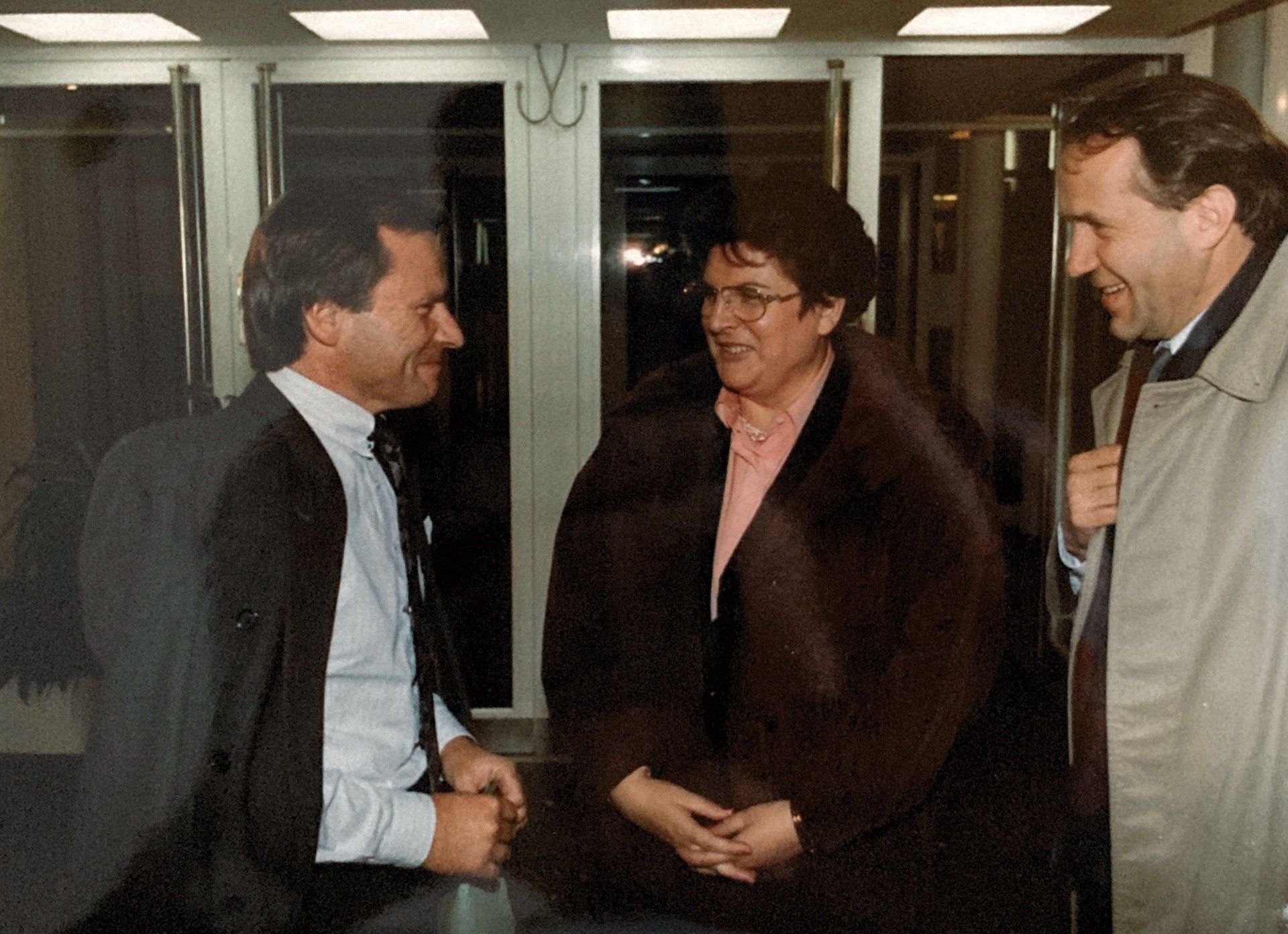 Ein Mann in Anzug und Krawatte spricht mit einer Frau im Pelzmantel