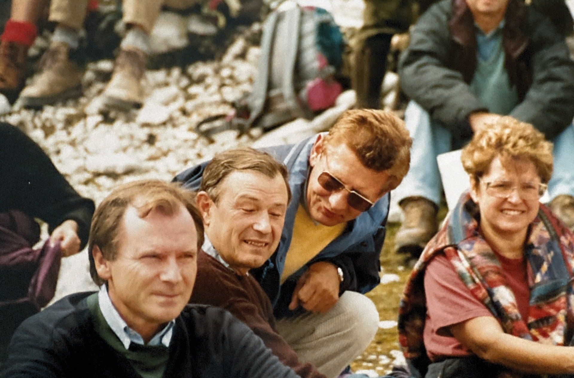 Eine Gruppe Leute sitzt auf dem Boden und lächelt.