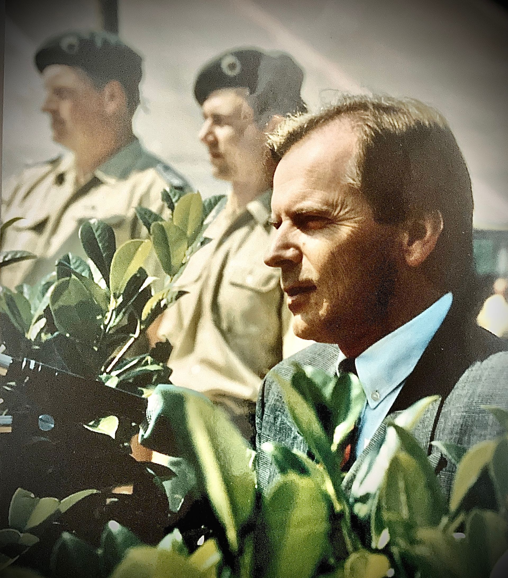 Ein Mann in Anzug und Krawatte ist von Soldaten umgeben