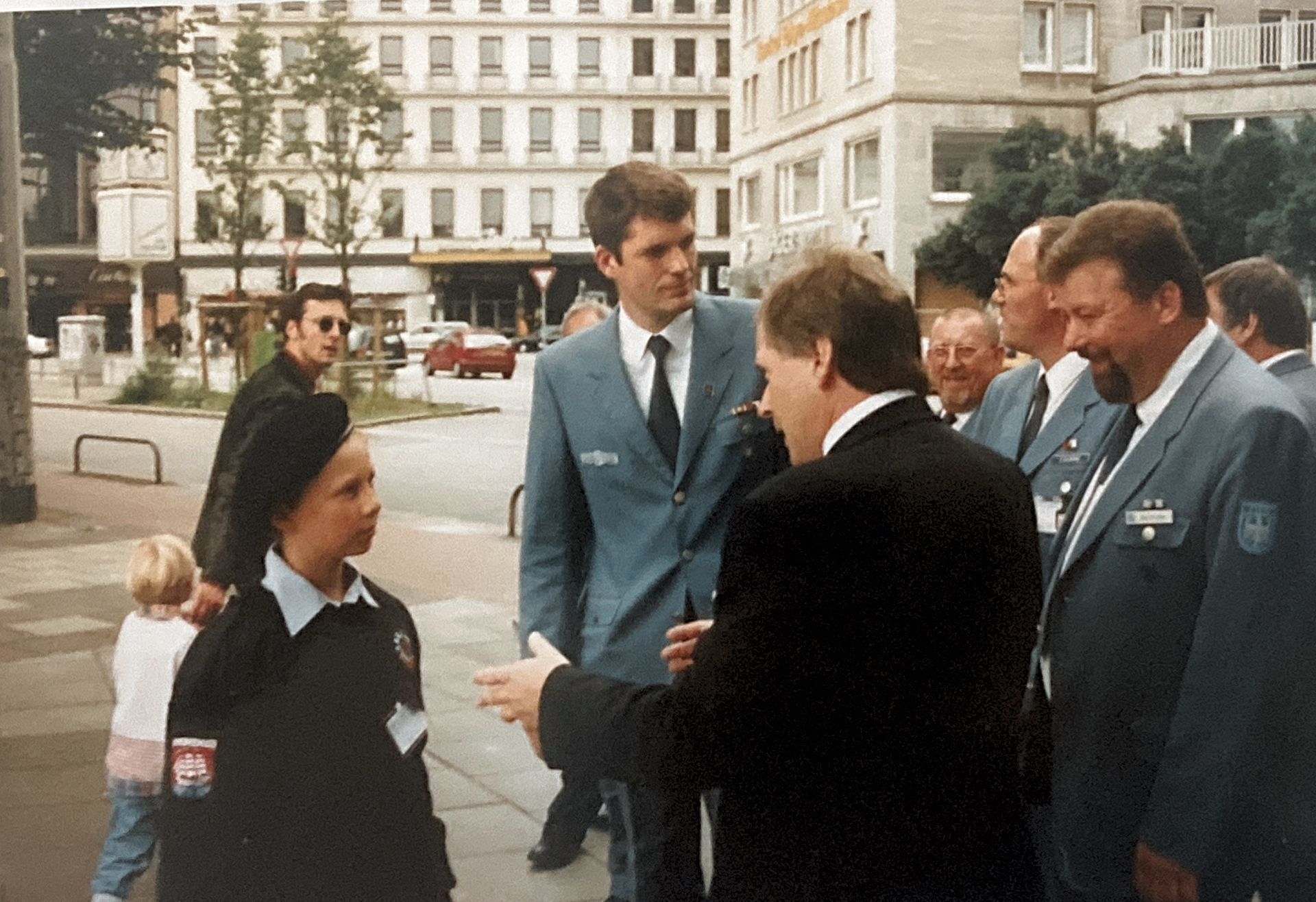 Eine Gruppe von Männern steht auf einem Bürgersteig und unterhält sich