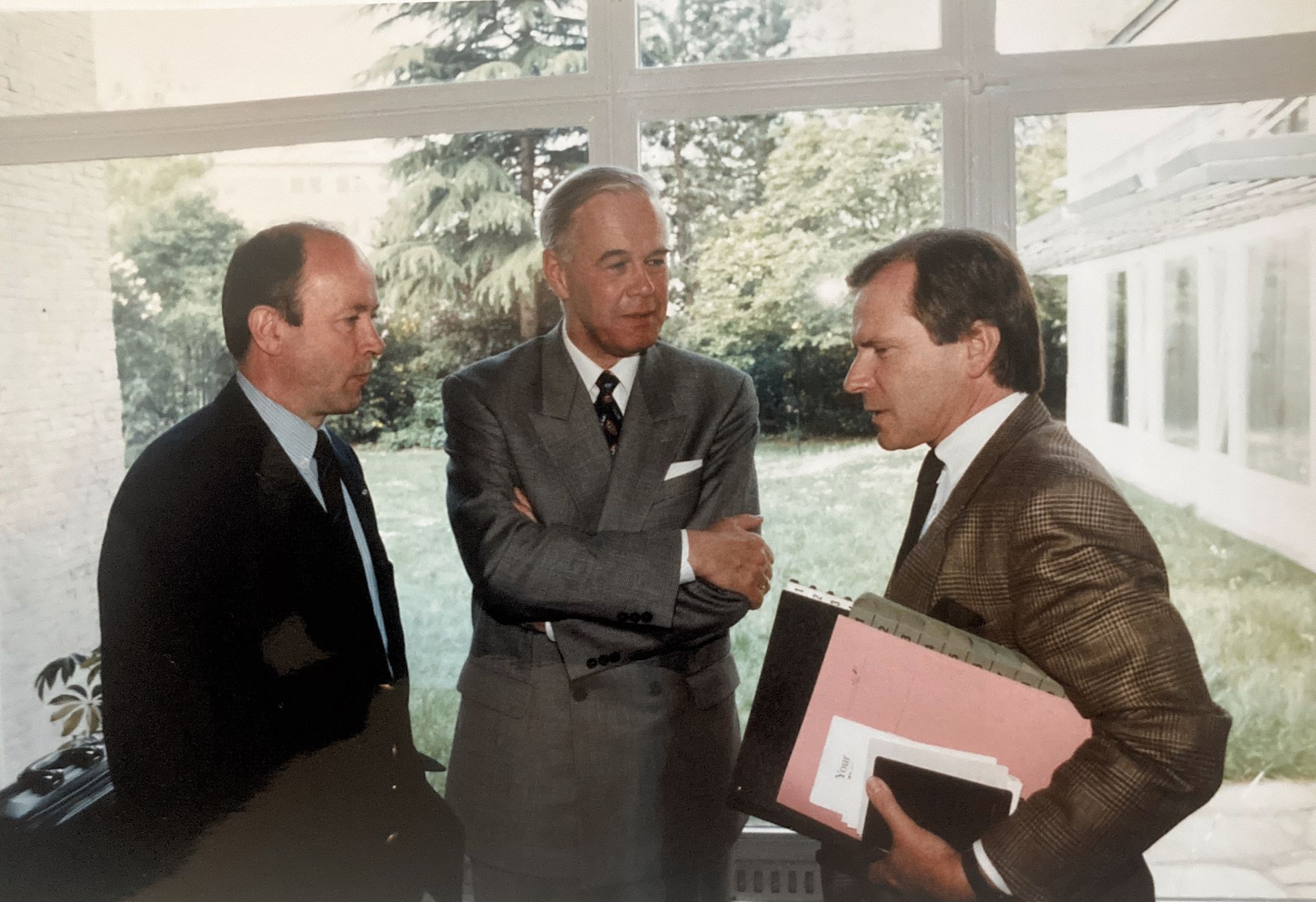 Drei Männer in Anzug und Krawatte stehen nebeneinander