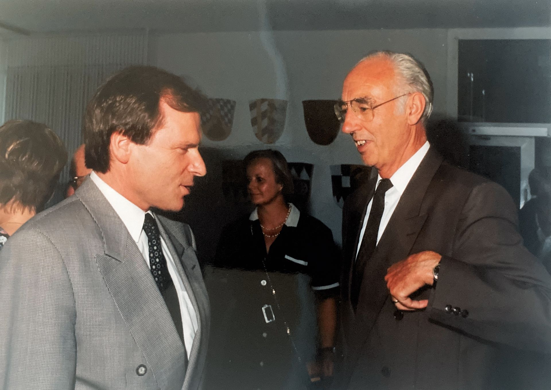 Zwei Männer in Anzug und Krawatte unterhalten sich miteinander