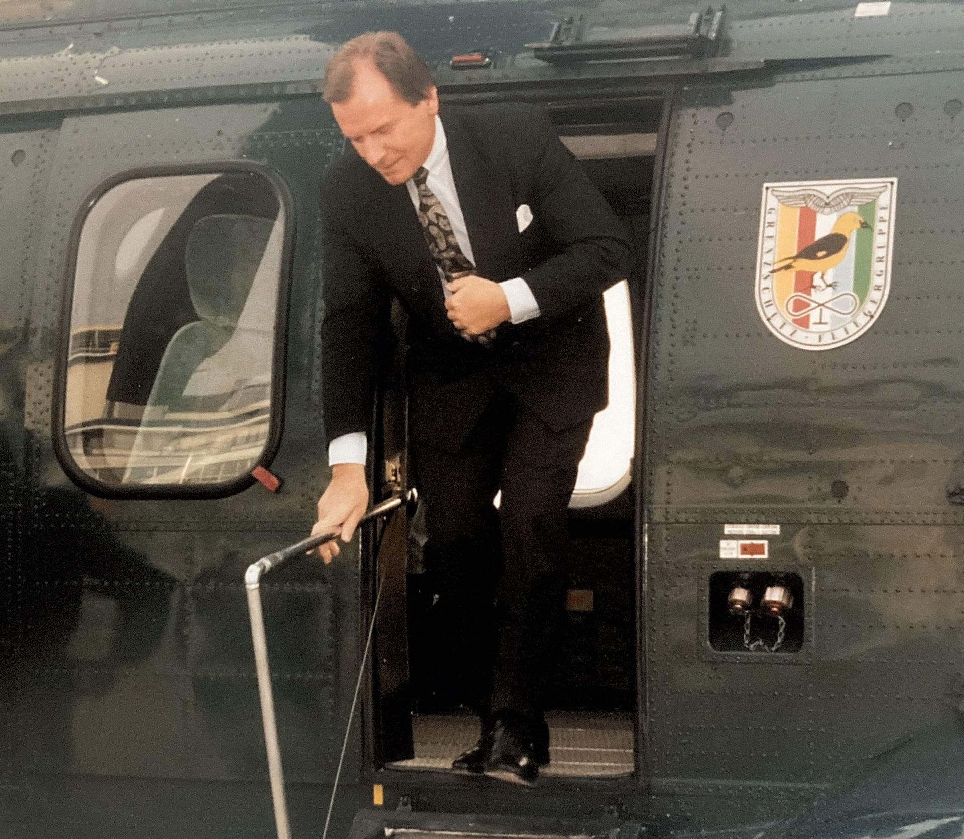 Ein Mann im Anzug steigt aus einem Hubschrauber