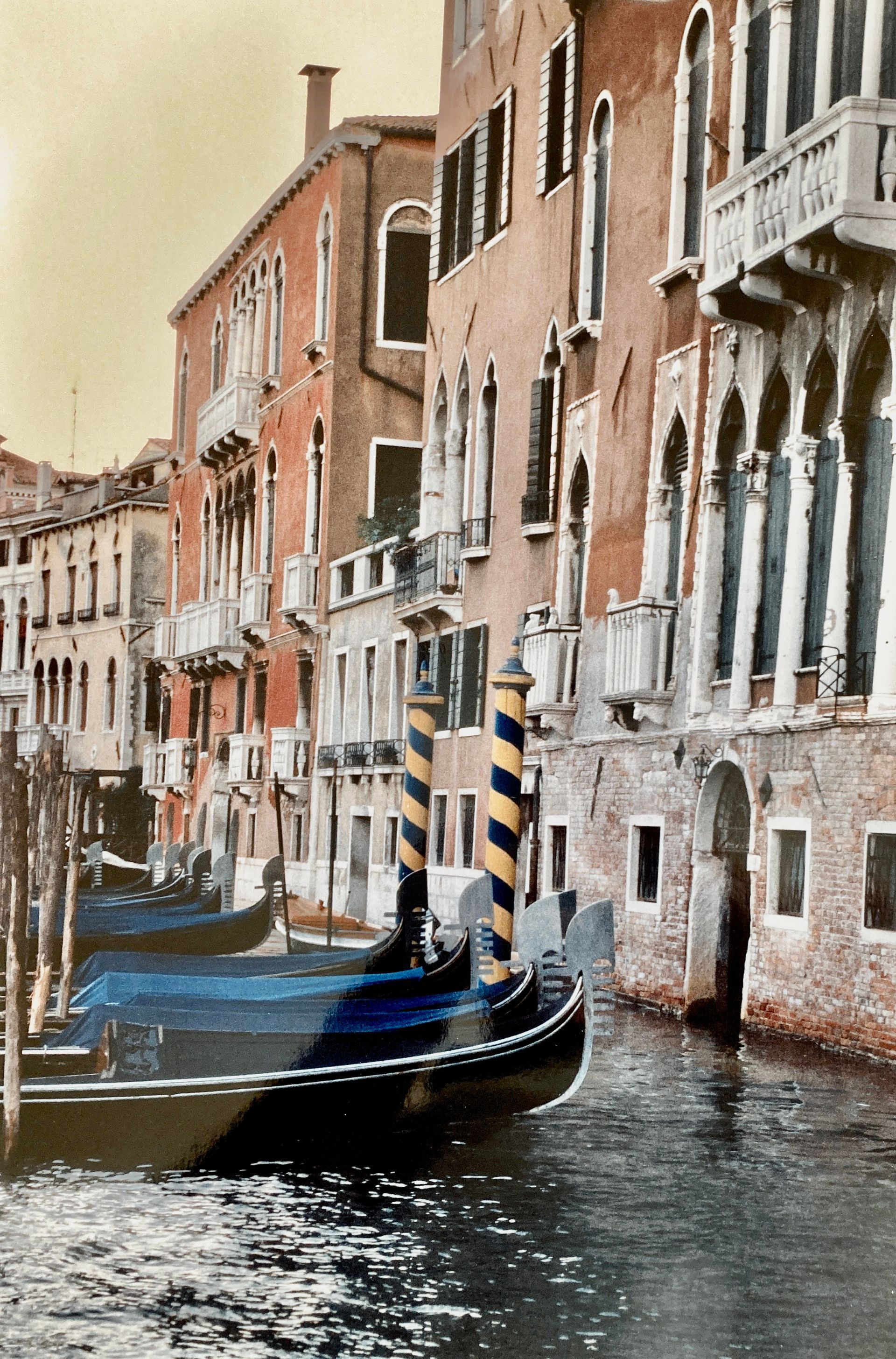 Eine Gondel fährt einen Kanal hinunter, im Hintergrund sind Gebäude zu sehen