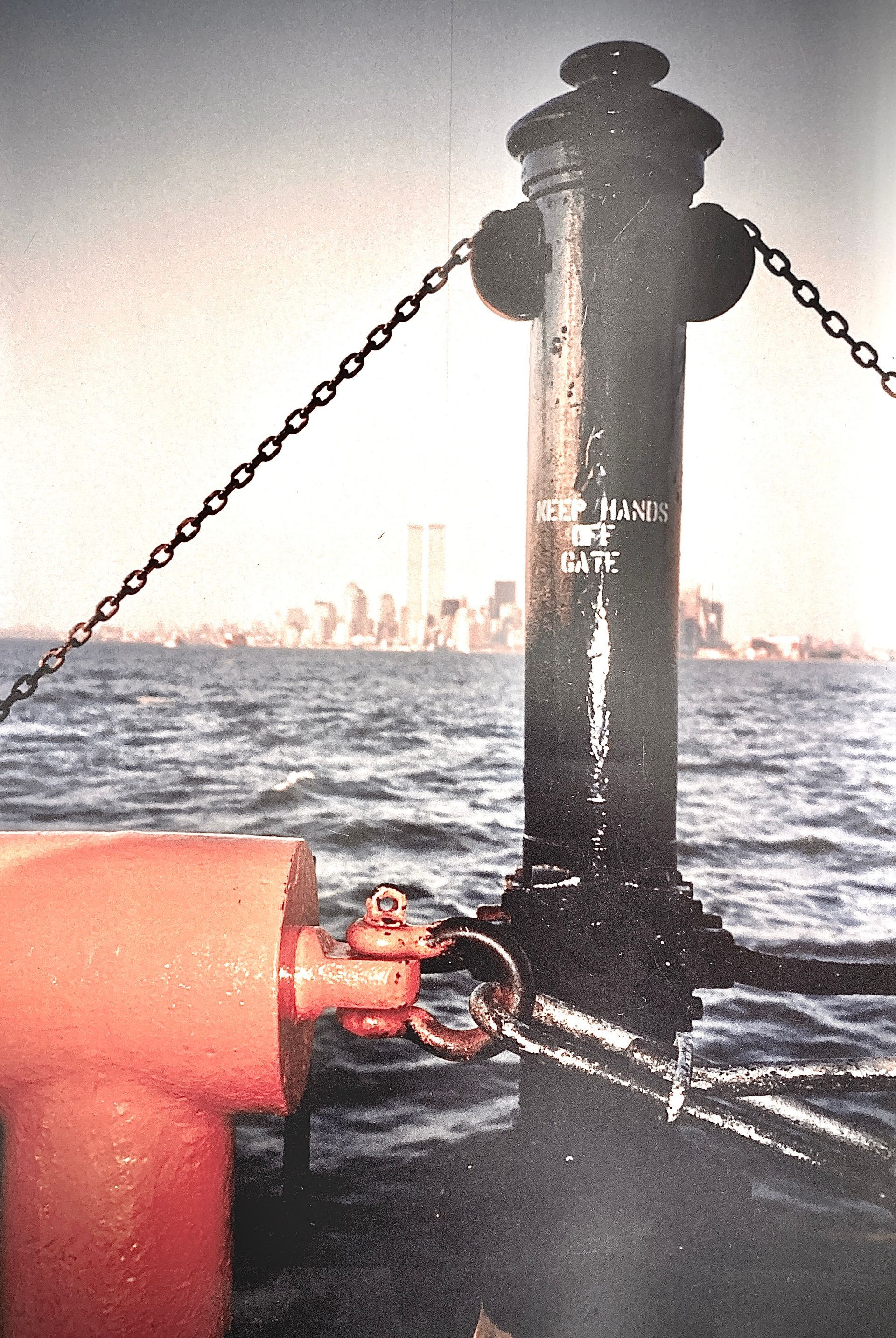 Ein Hydrant ist von Ketten umgeben und steht vor einem Gewässer