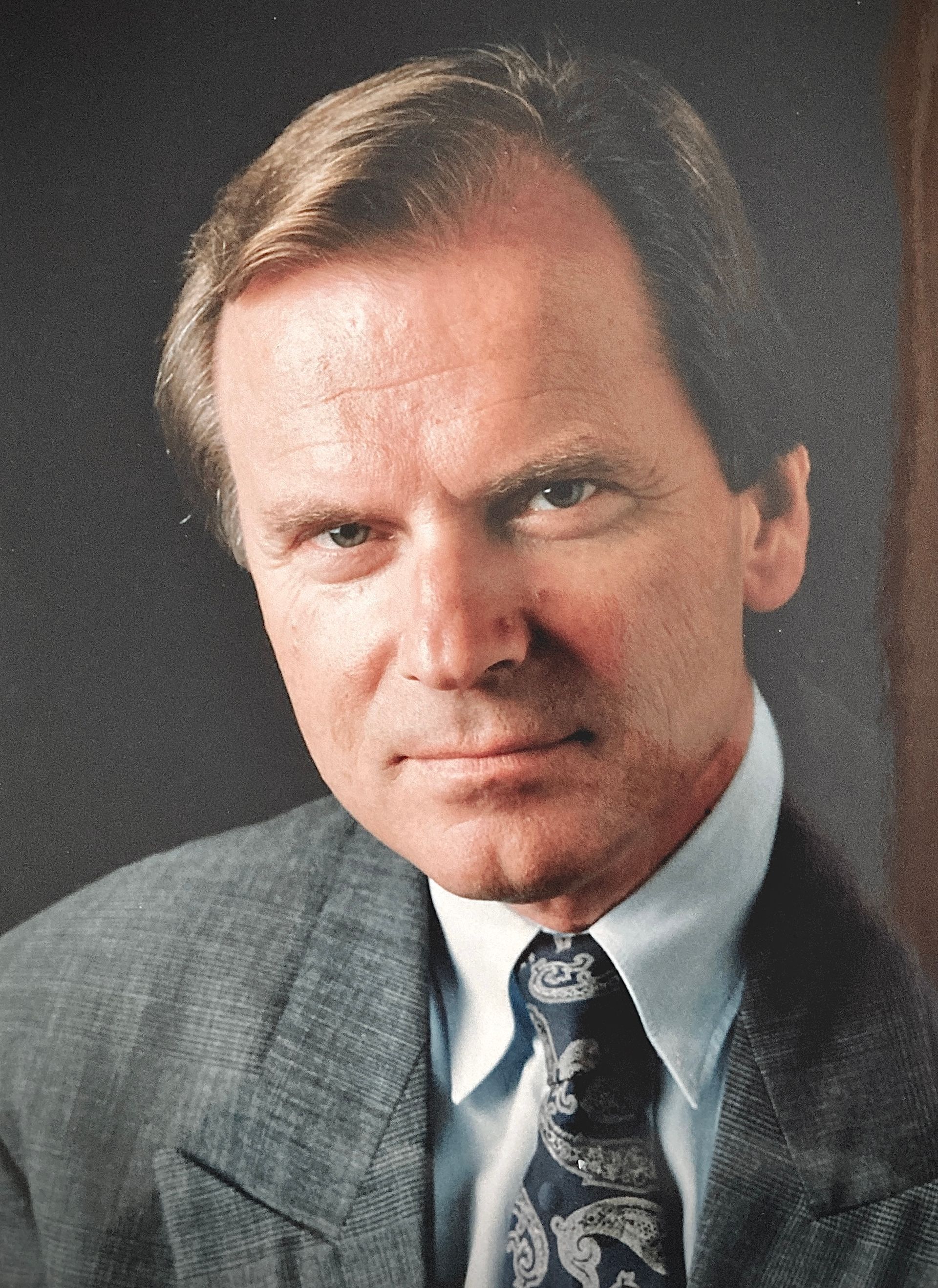 Ein Mann in Anzug und Krawatte blickt in die Kamera