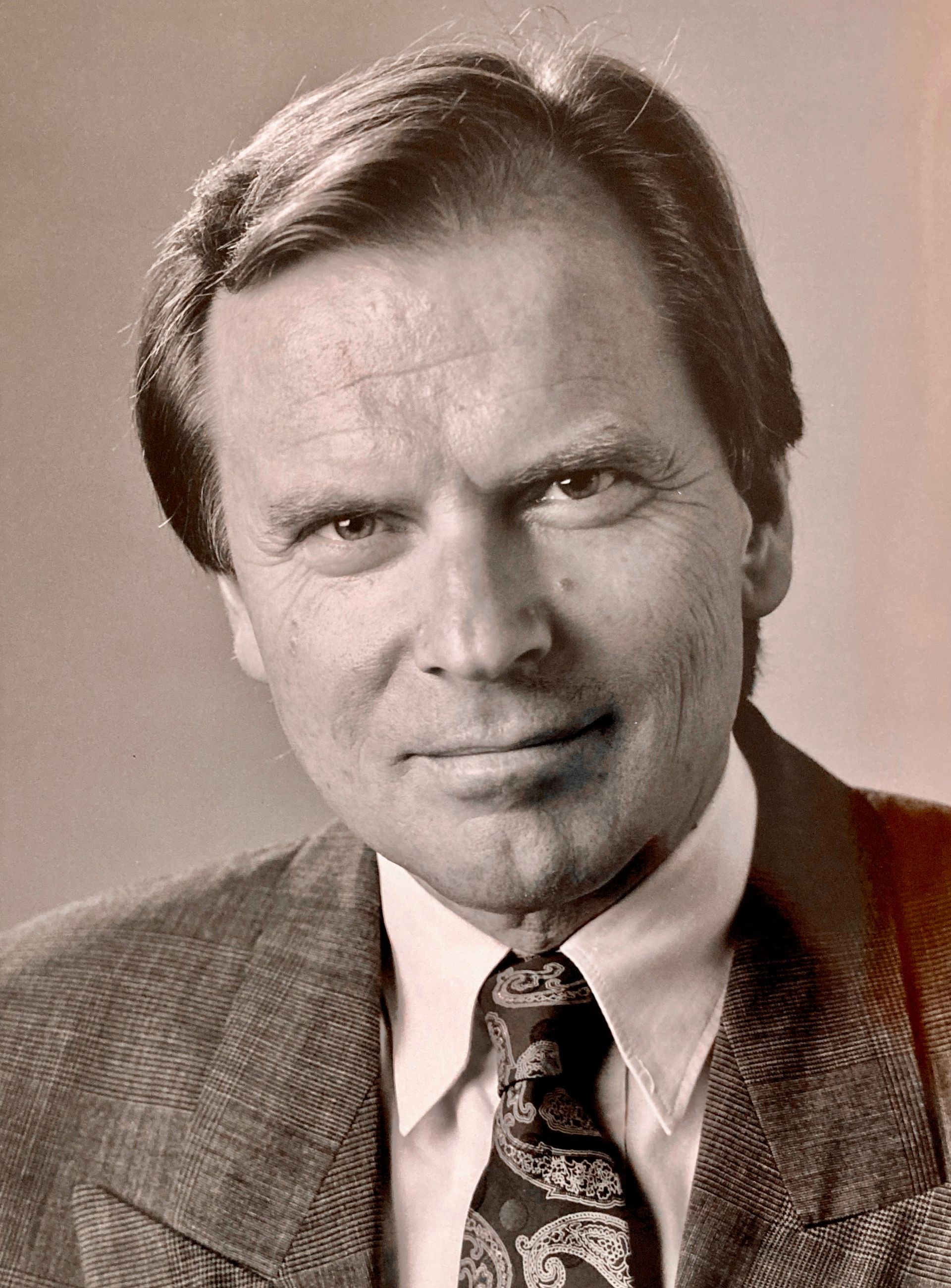 Ein Schwarzweißfoto eines Mannes in Anzug und Krawatte