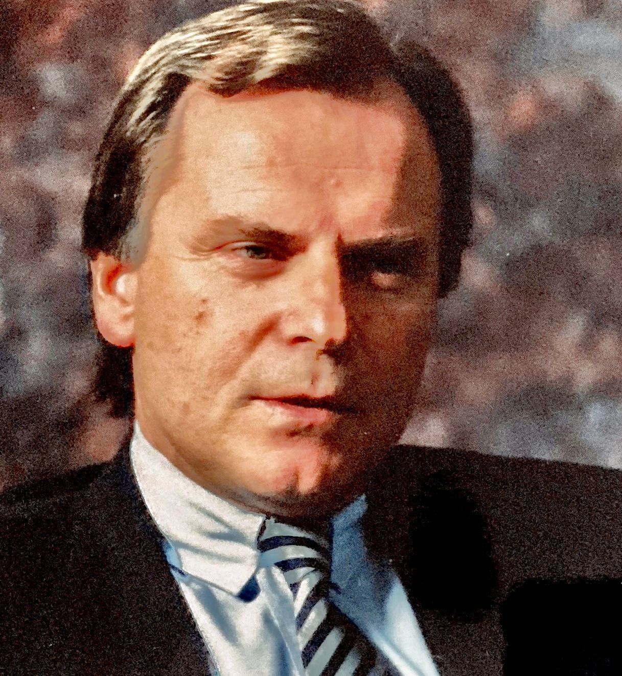 Ein Mann in Anzug und Krawatte blickt in die Kamera