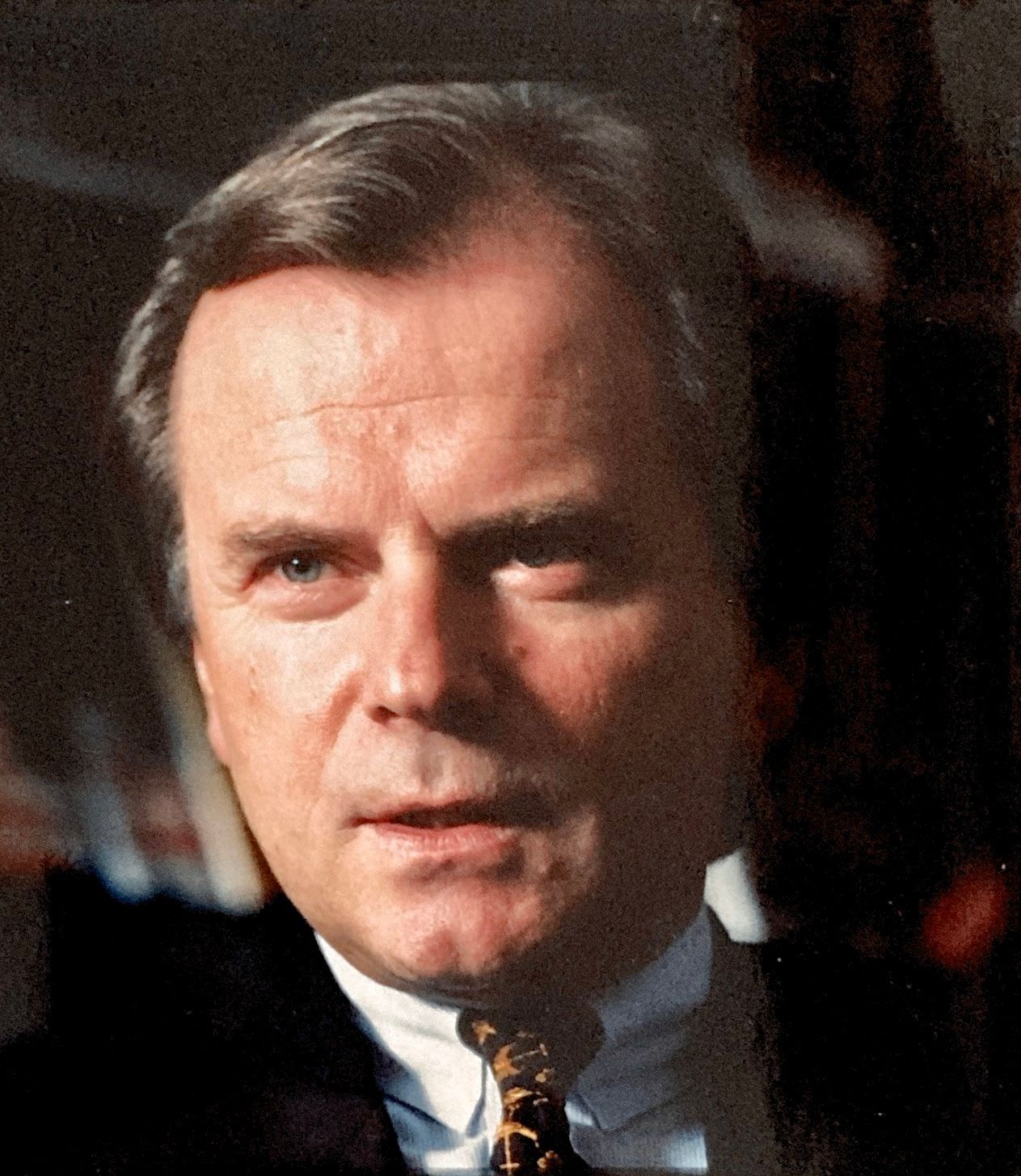 Ein Mann in Anzug und Krawatte blickt in die Kamera