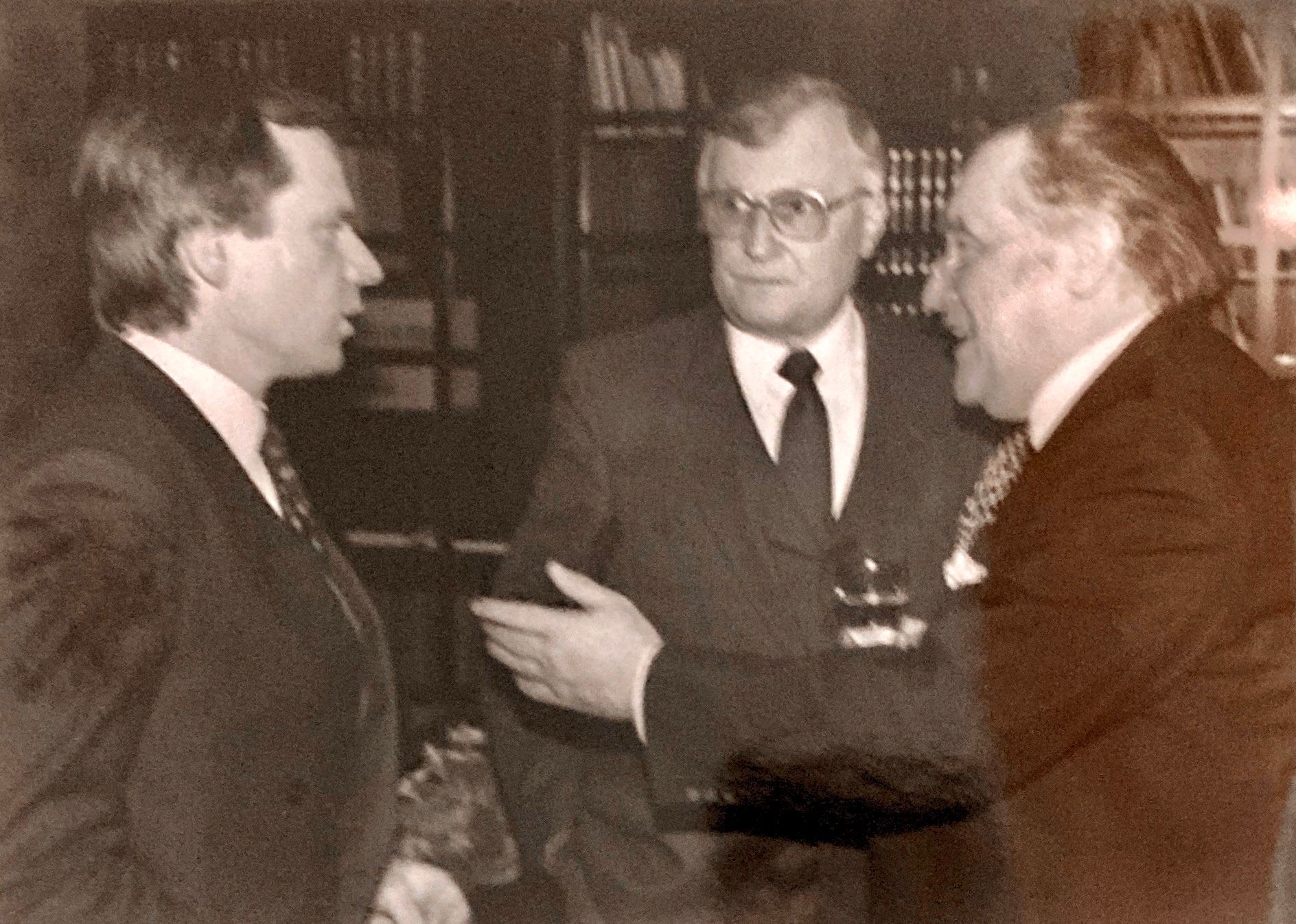 Drei Männer in Anzug und Krawatte unterhalten sich miteinander