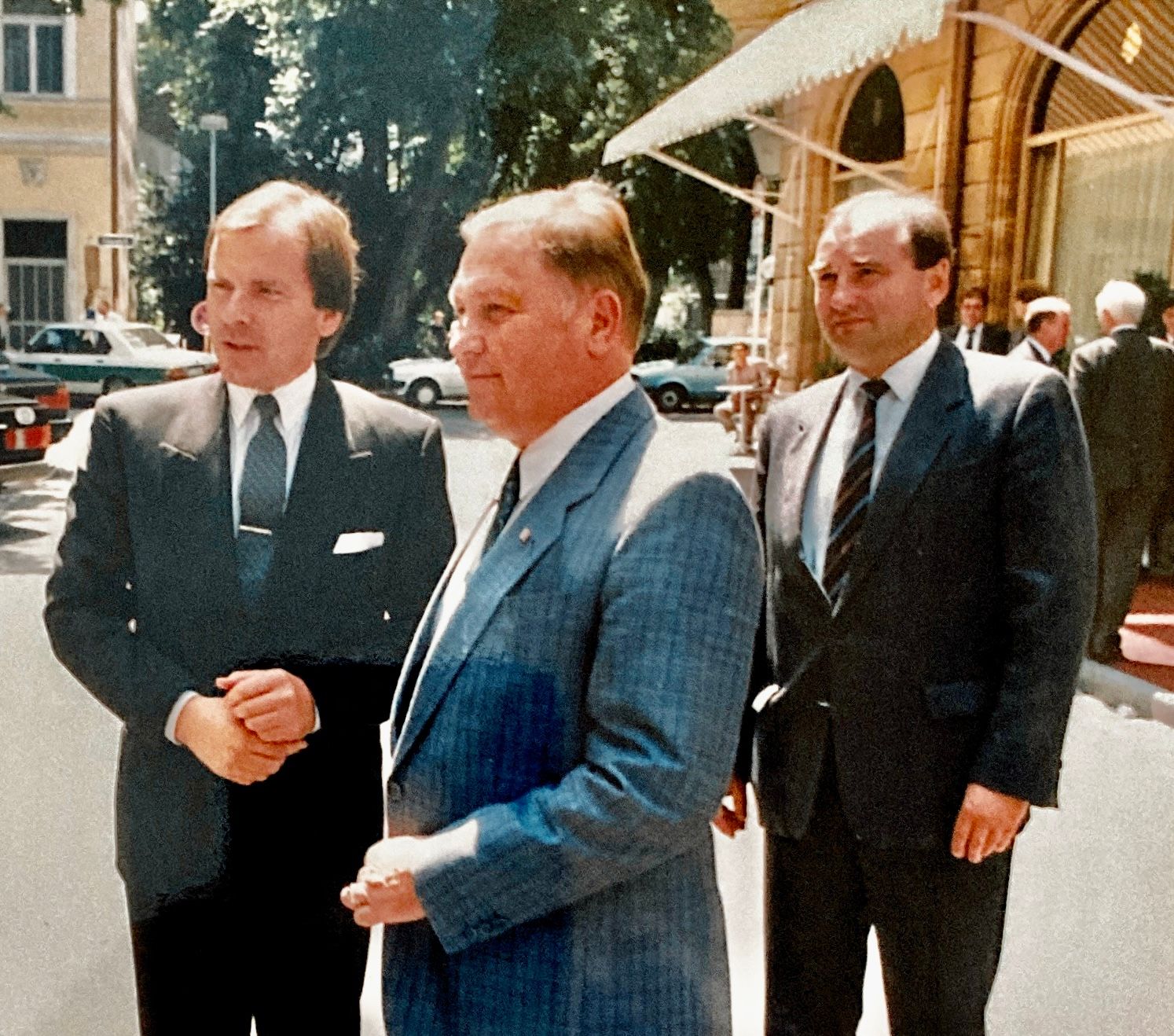 Drei Männer in Anzug und Krawatte stehen nebeneinander