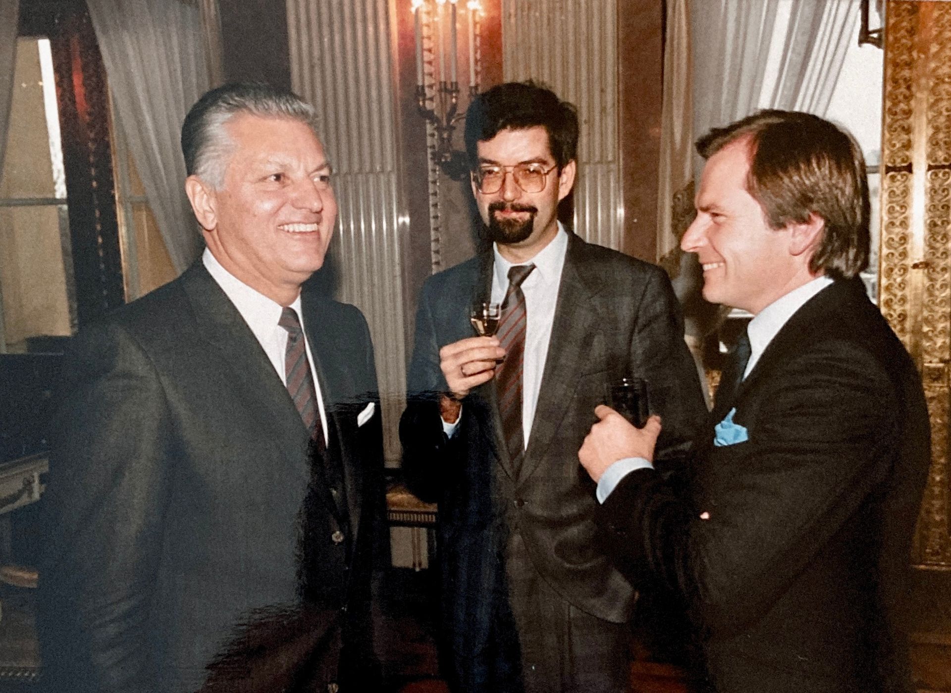 Drei Männer in Anzug und Krawatte unterhalten sich