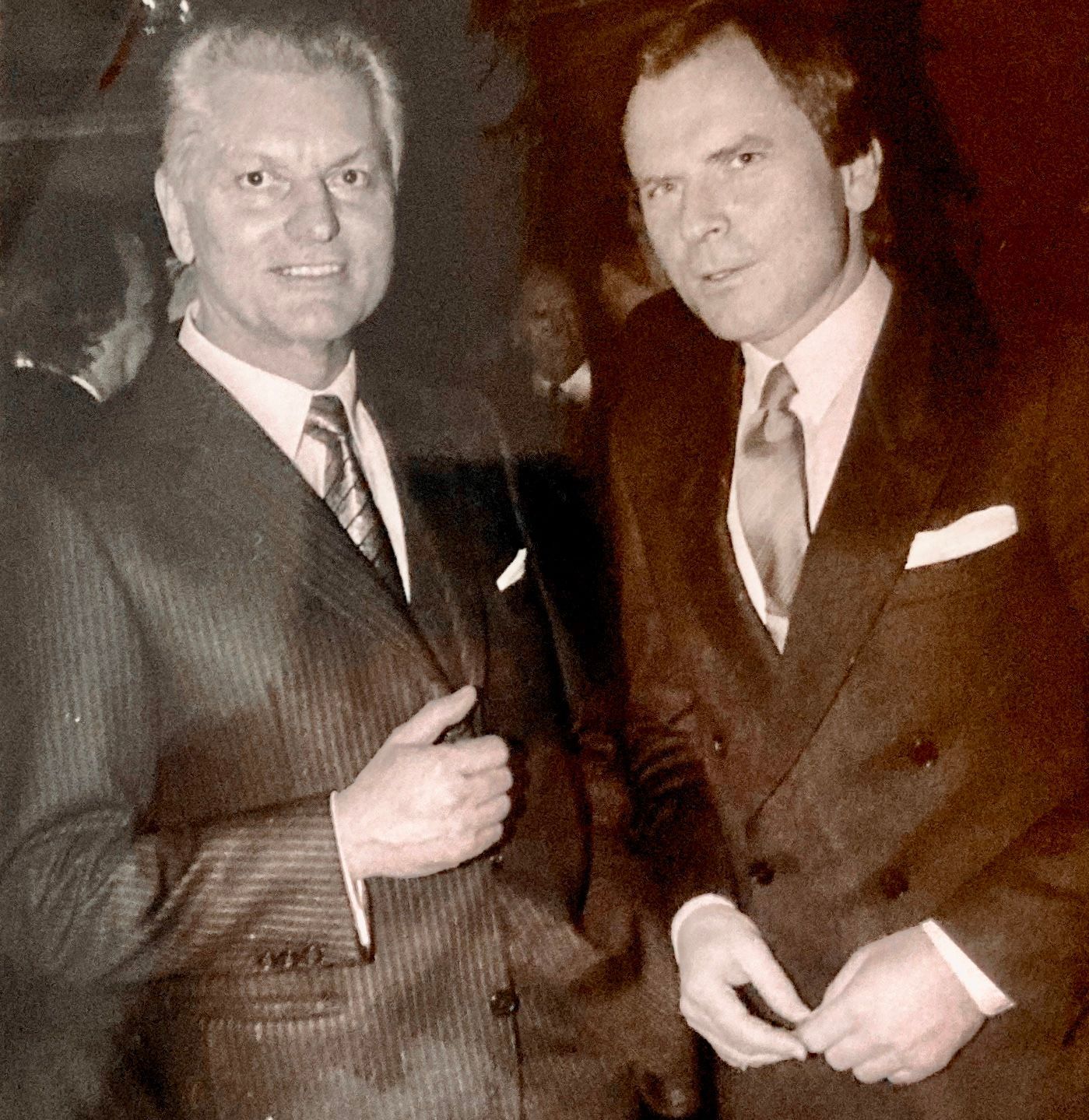 Zwei Männer in Anzug und Krawatte stehen nebeneinander