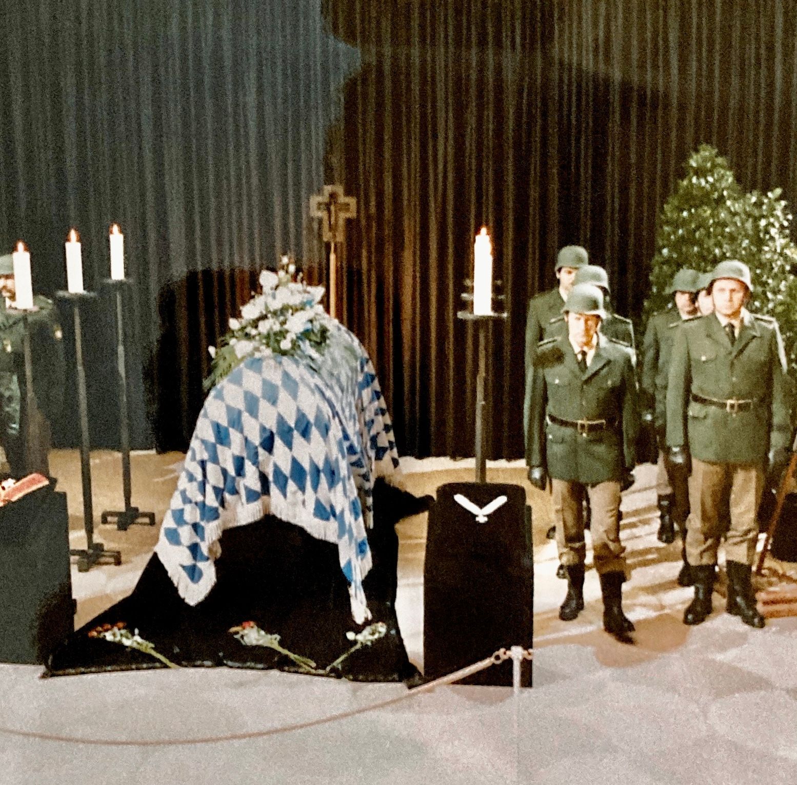 Eine Gruppe Soldaten steht um einen Sarg herum