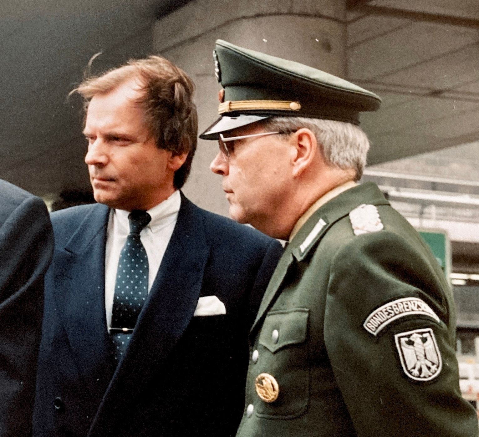 Ein Mann in Anzug und Krawatte steht neben einem Mann in Militäruniform