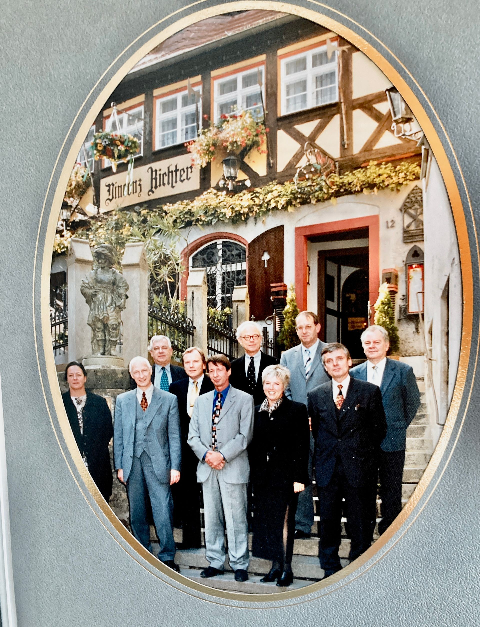 Eine Gruppe von Männern steht vor einem Gebäude mit einem Schild mit der Aufschrift „Bräu Richter“