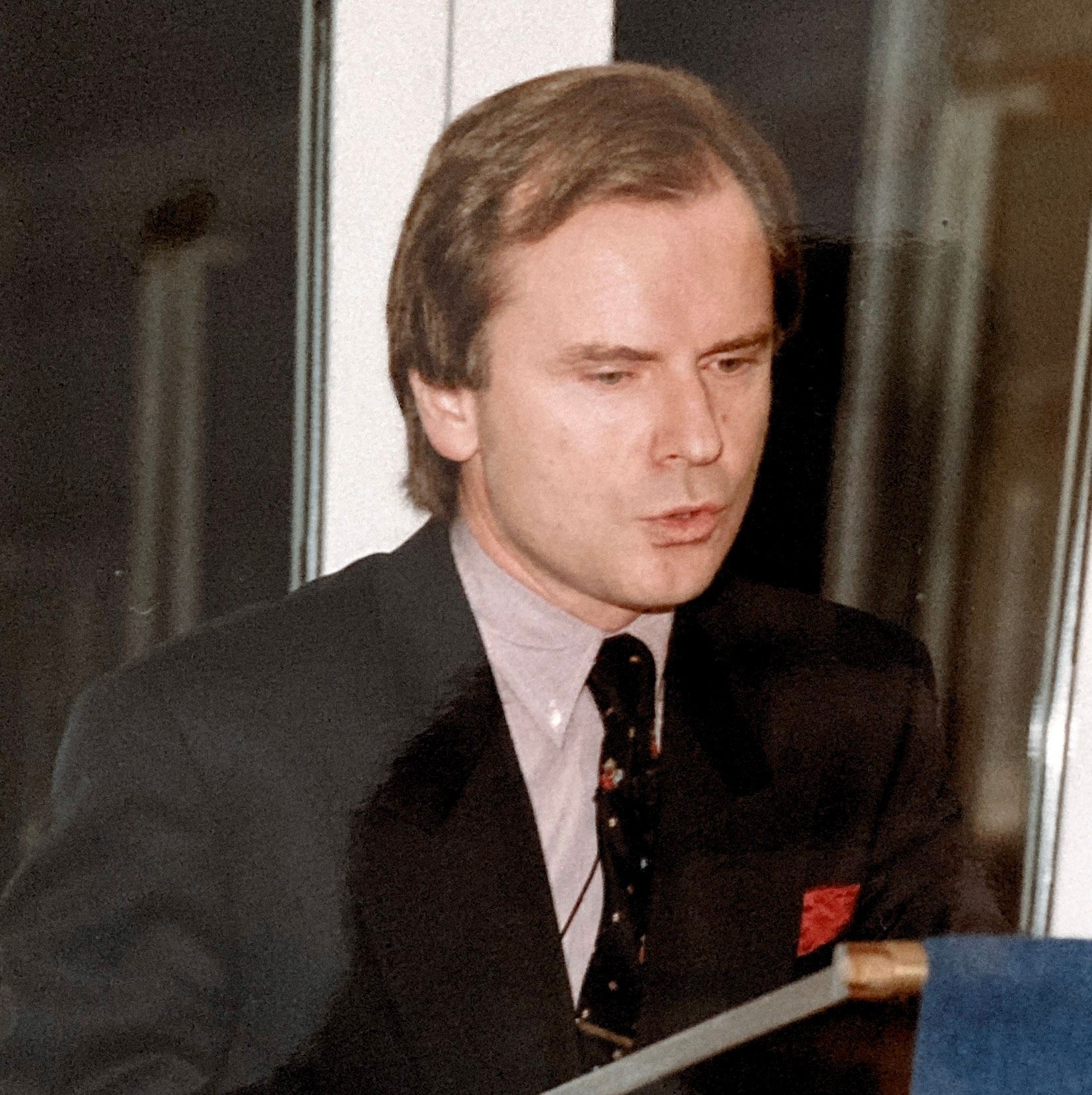 Ein Mann in Anzug und Krawatte hält eine Rede