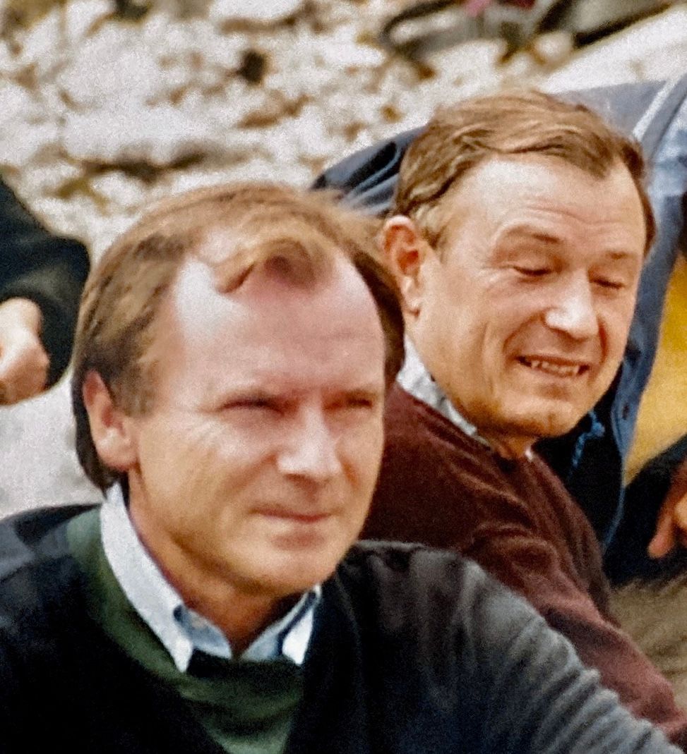 Eine Gruppe Männer sitzt nebeneinander und lächelt.